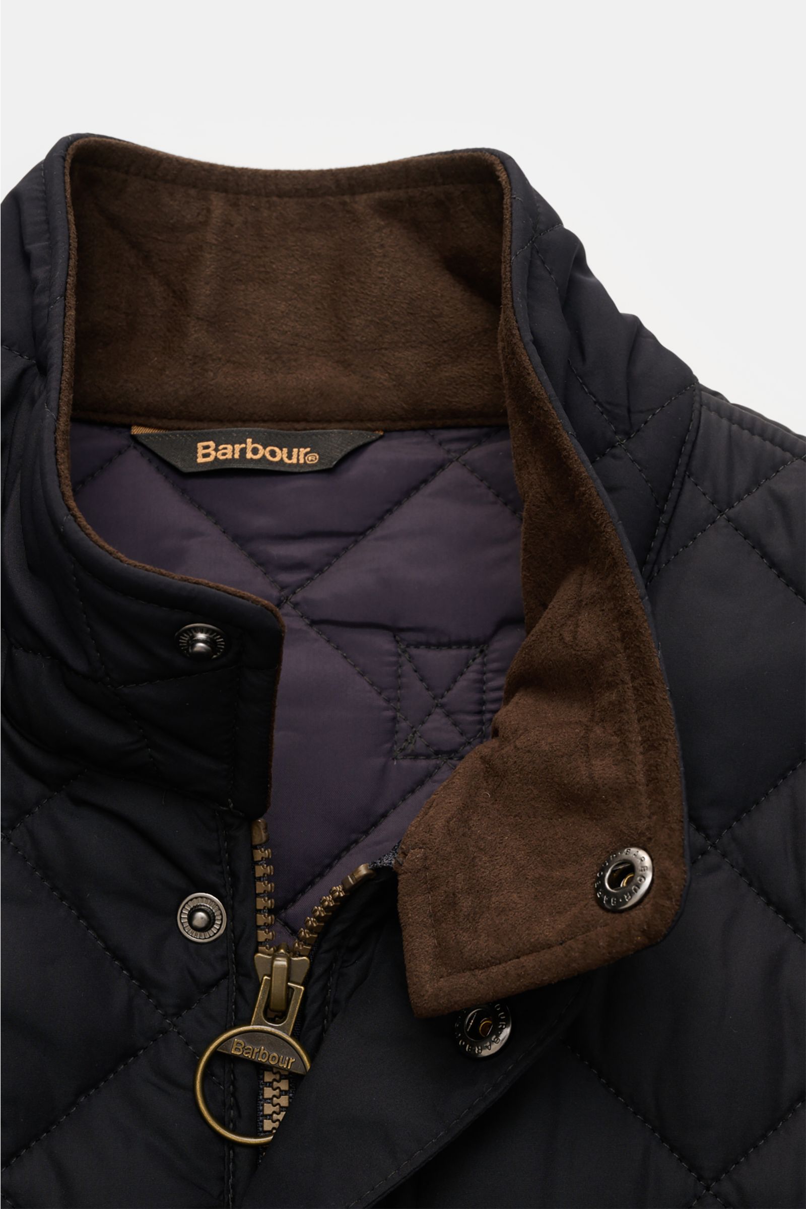 Barbour Steppweste 'New Lowerdale' dark navy in Nahaufnahme von oben, mit hochwertiger Microfaser, weichem Griff, Stehkragen, robuster Zwei-Wege-Reißverschluss und wattierter Rautensteppung.