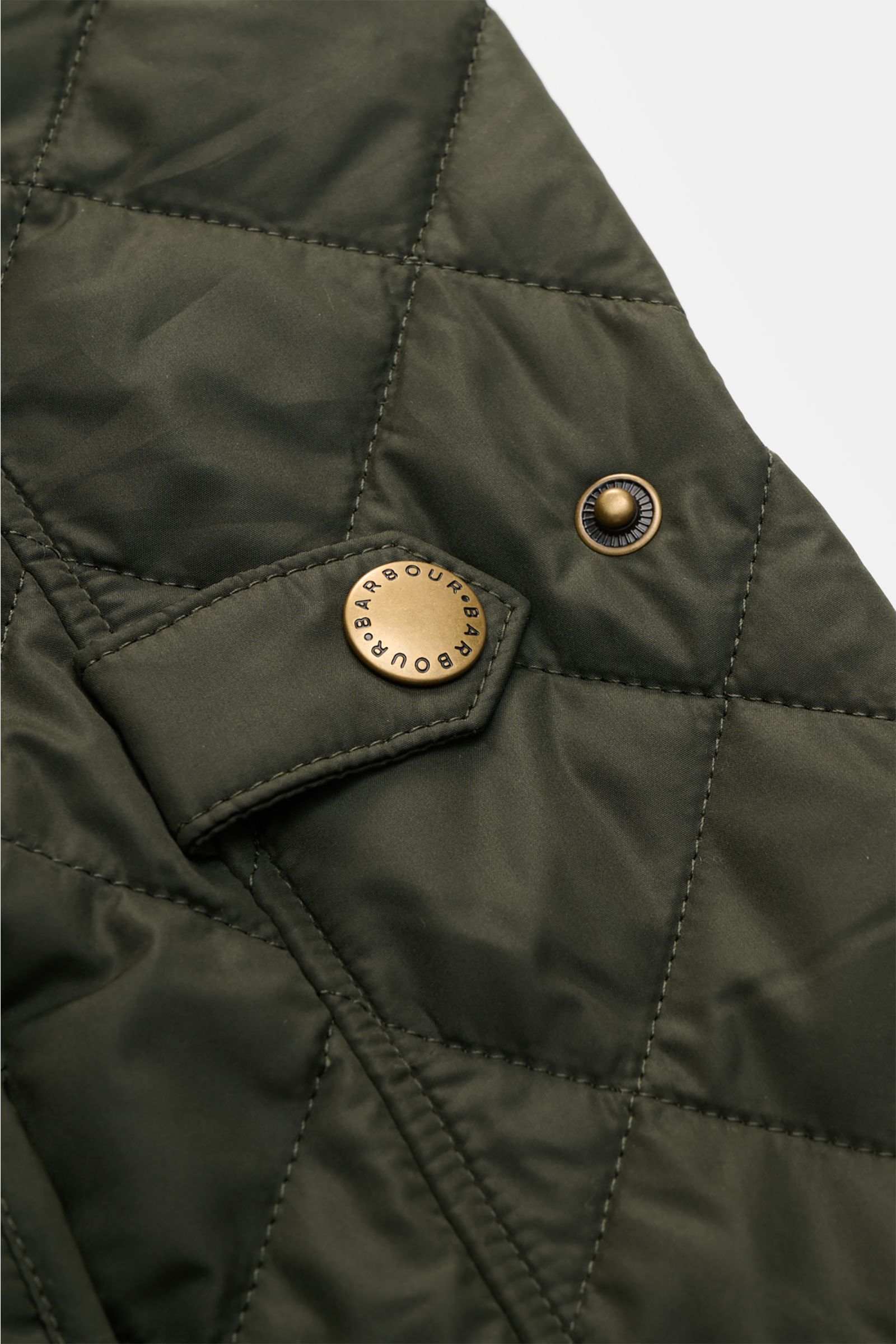 Barbour Steppweste 'New Lowerdale' dunkelgrün in Nahaufnahme, leichte Microfaser-Wattierung, Rautenstepp, Druckknopf, tonales Logo-Stitching.