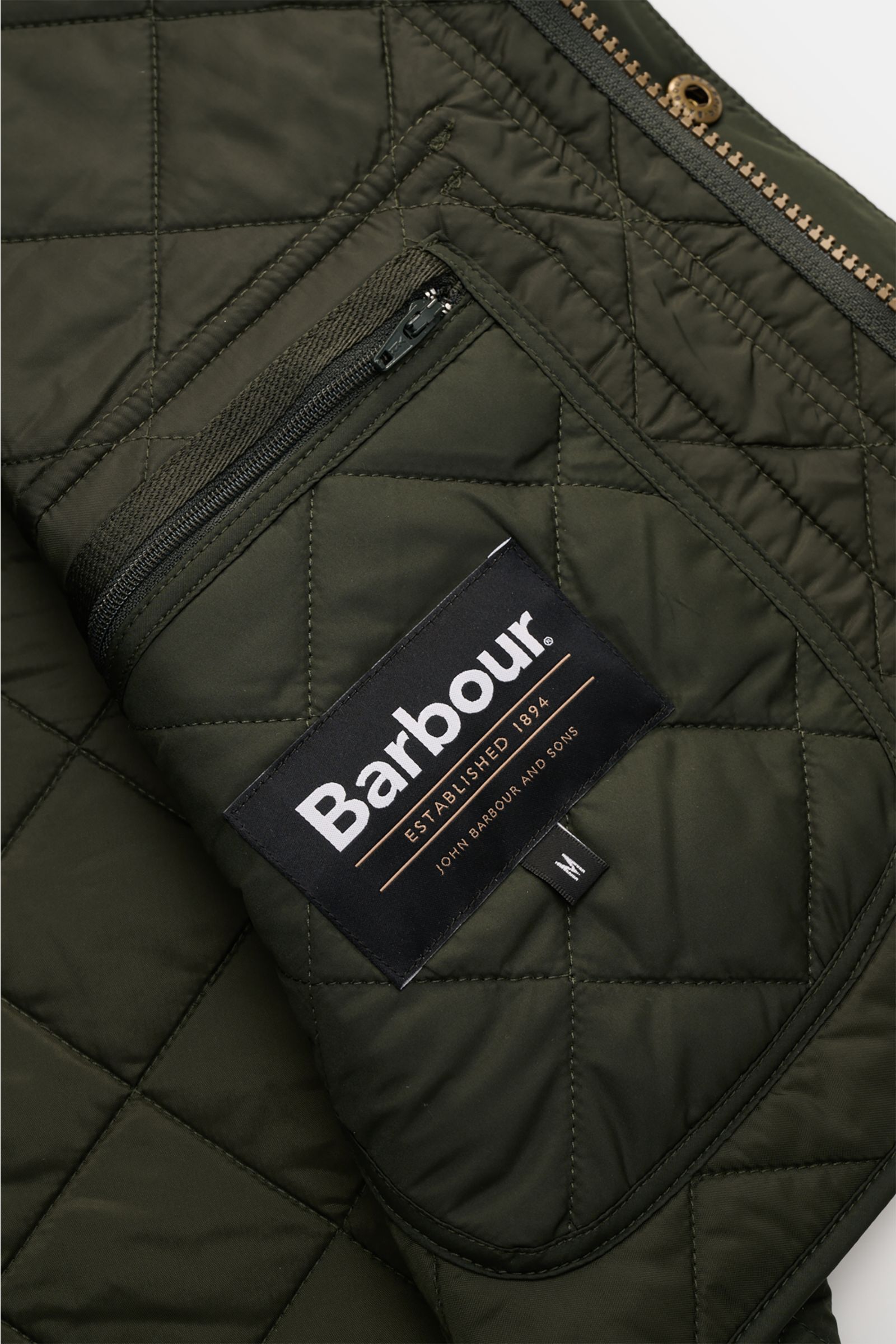 Barbour Steppweste 'New Lowerdale' dunkelgrün, Detailaufnahme von innen mit tonalem Rautenstepp, Reißverschluss-Innentasche, weicher Microfaser.
