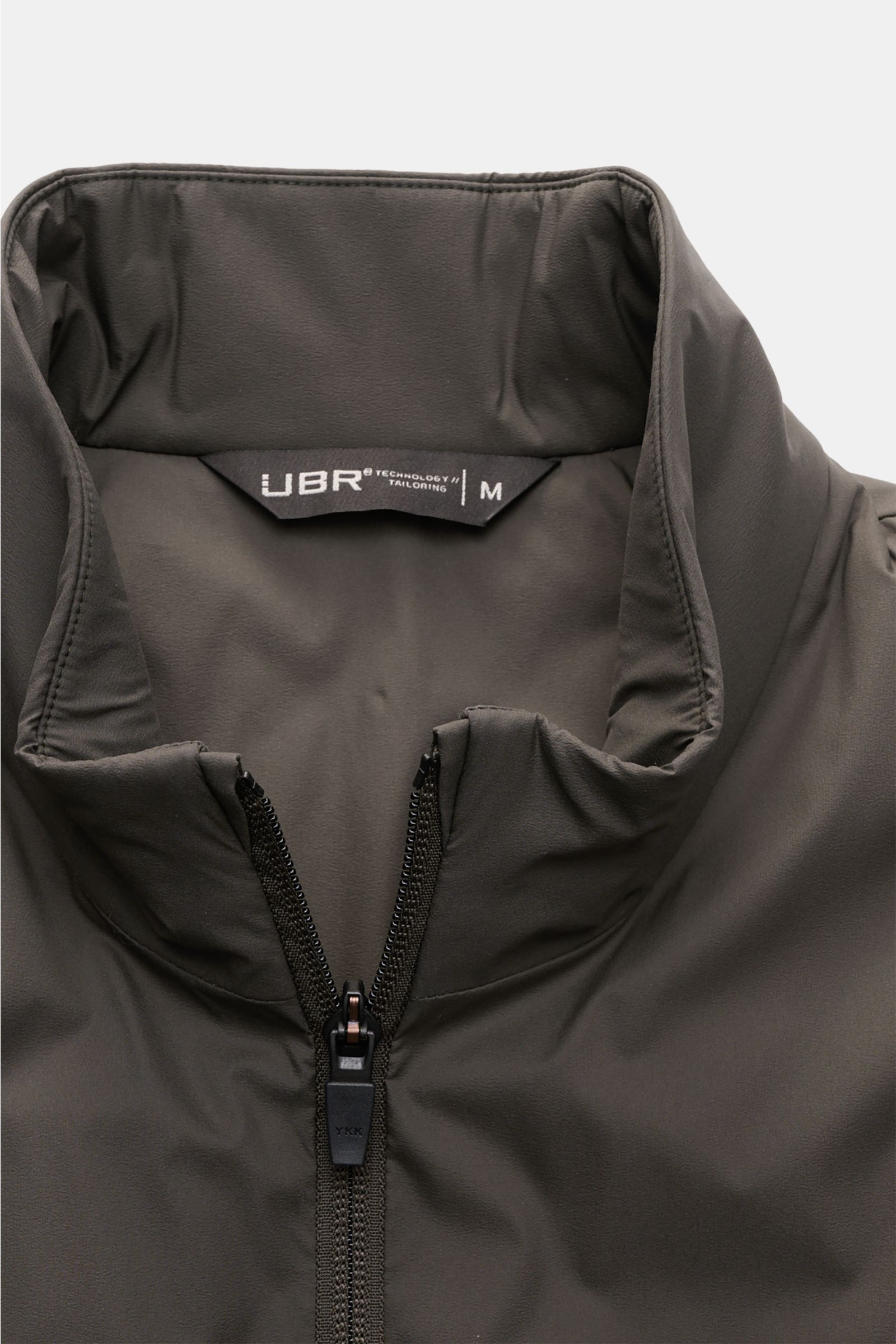 UBR Outdoor-Weste 'Raptor' oliv in Nahaufnahme von oben, leichte Microfaser, Slim Fit, Stehkragen, Zwei-Wege-Reißverschluss, reflektierende Details.