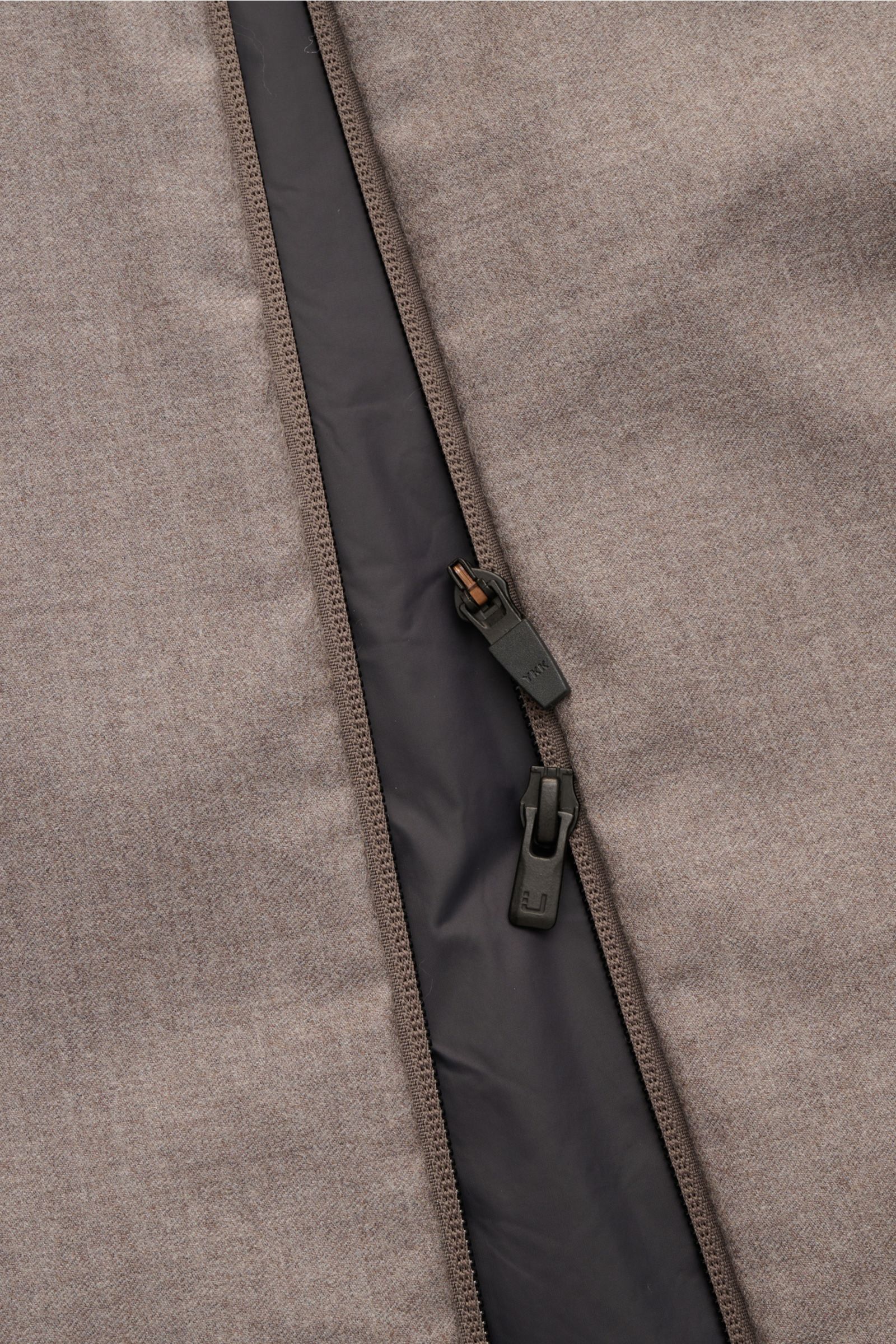 Nahaufnahme der UBR Outdoorweste 'Raptor Savile' taupe meliert mit leicht geöffnetem Zwei-Wege-Reißverschluss, weichem Futter und Slim Fit, reine Wolle, Stehkragen, schräge Leistentaschen, sportiv und komfortabel.