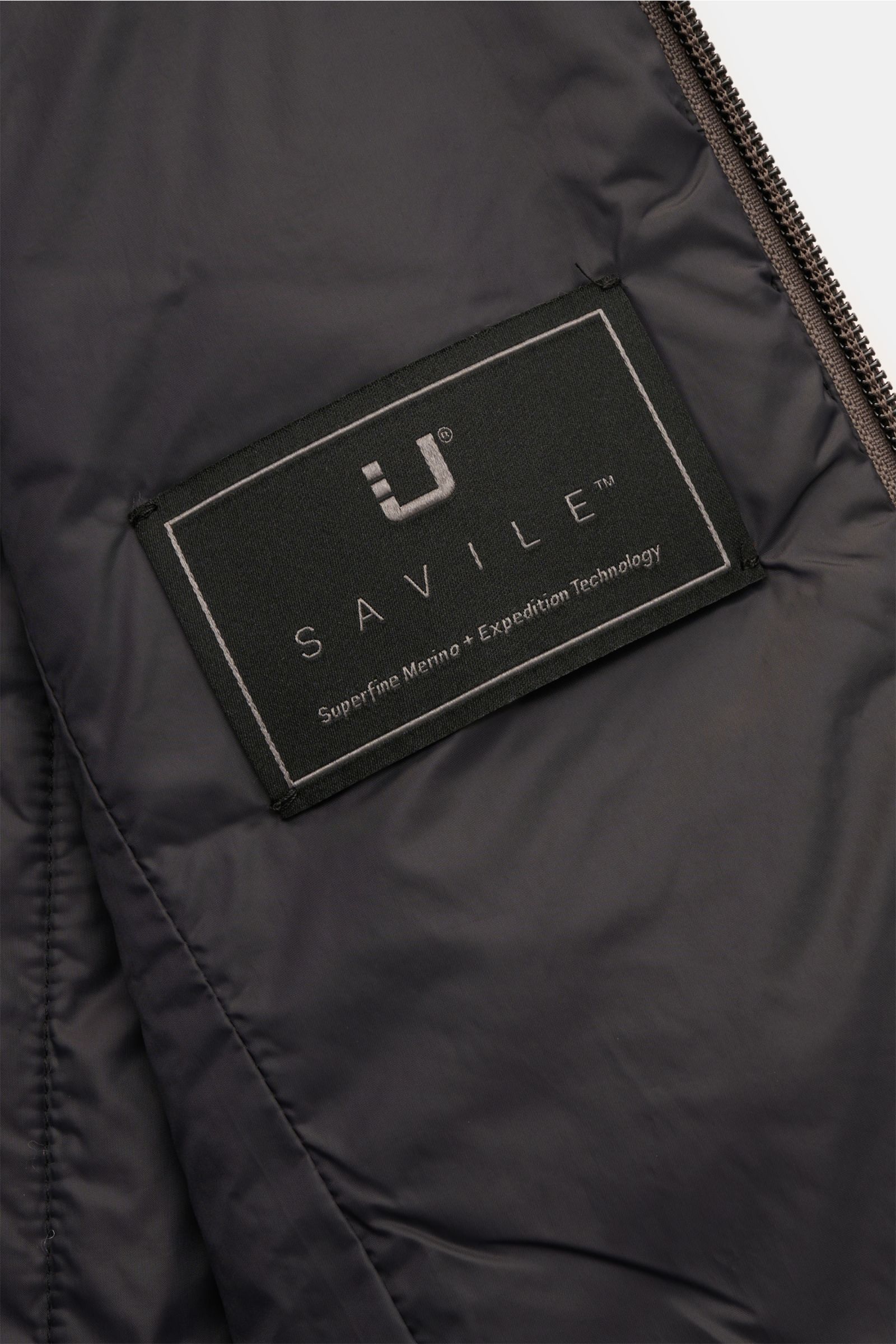 Innenansicht der UBR Outdoorweste 'Raptor Savile' taupe meliert mit Label, weichem Futterstoff und feiner Wattierung.