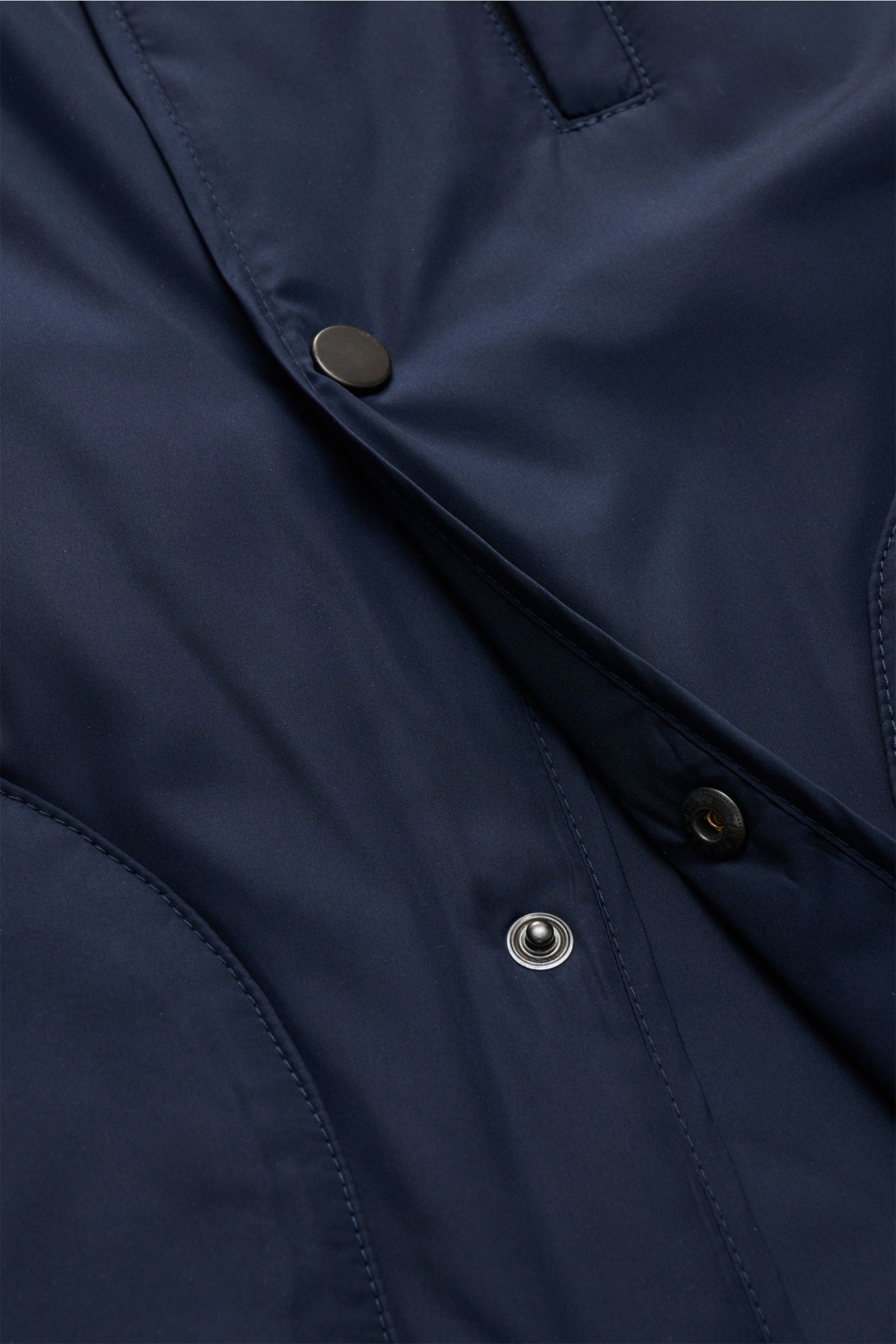 Nahaufnahme aus schräger Perspektive der navyfarbenen 04651/ A trip in a bag Outdoorweste 'Padded Nylon' mit Five-Knopf-Leiste und glattem Microfaserstoff.