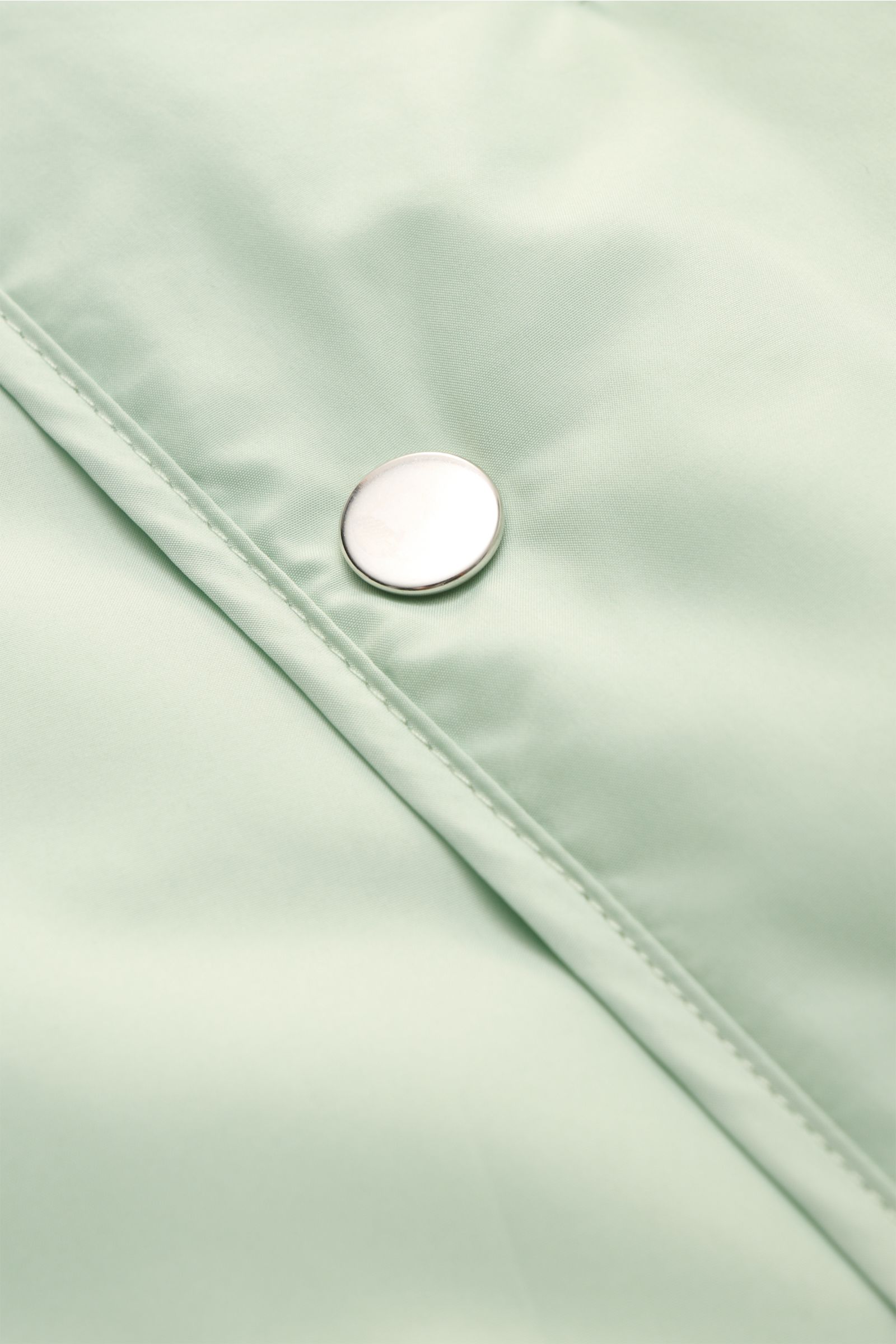 Nahaufnahme der pastellgrünen 04651/ A trip in a bag Outdoorweste 'Padded Nylon' mit Slim Fit, Fünf-Knopf-Leiste und glattem Microfaserstoff.