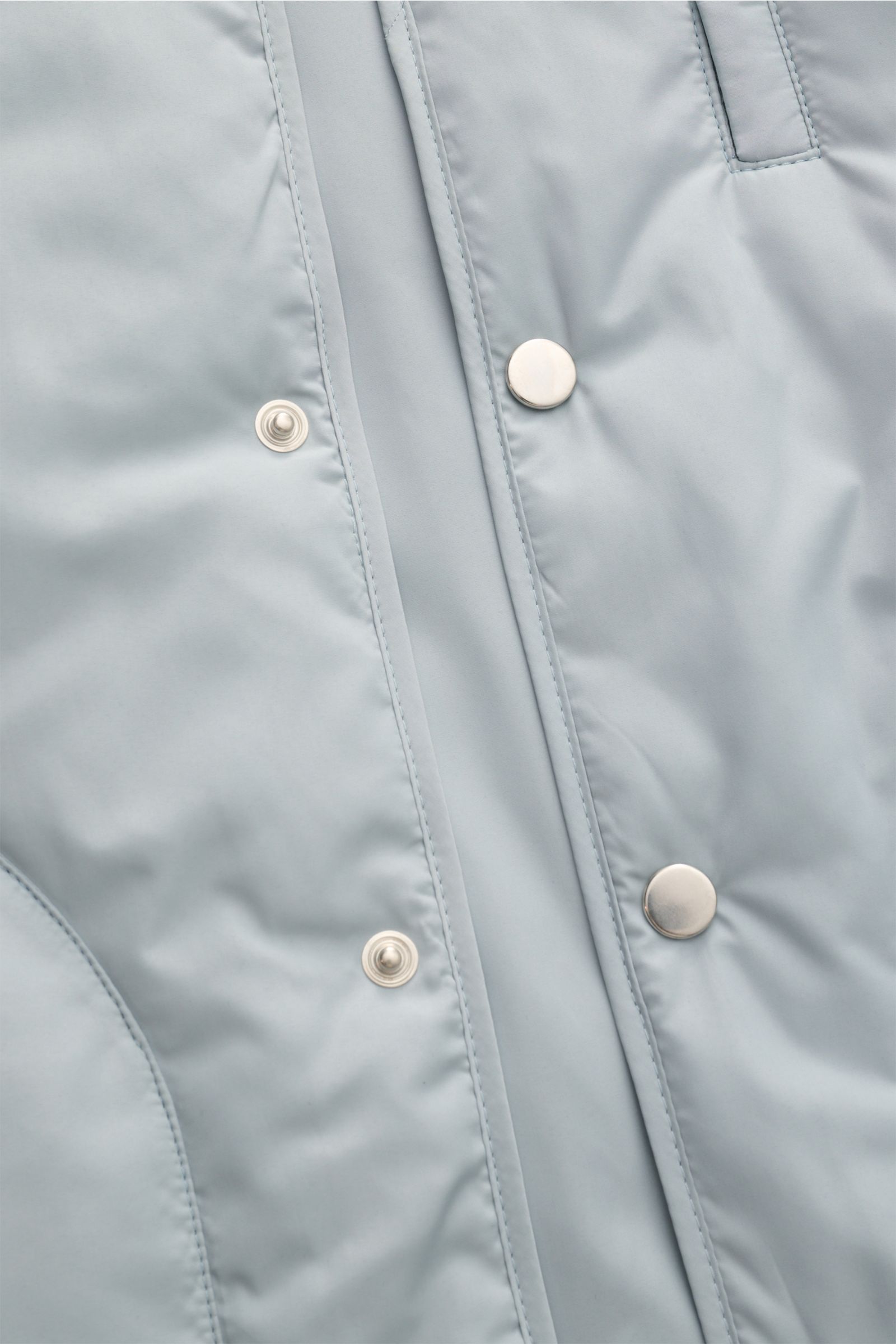 Close-up front view of the light gray 04651/ A trip in a bag Outdoor Weste 'MC26' showing snap buttons on smooth high-quality microfiber fabric with light padding. Inspired by Cortina and Milan Winter Olympics, this slim fit vest features a stand collar, 