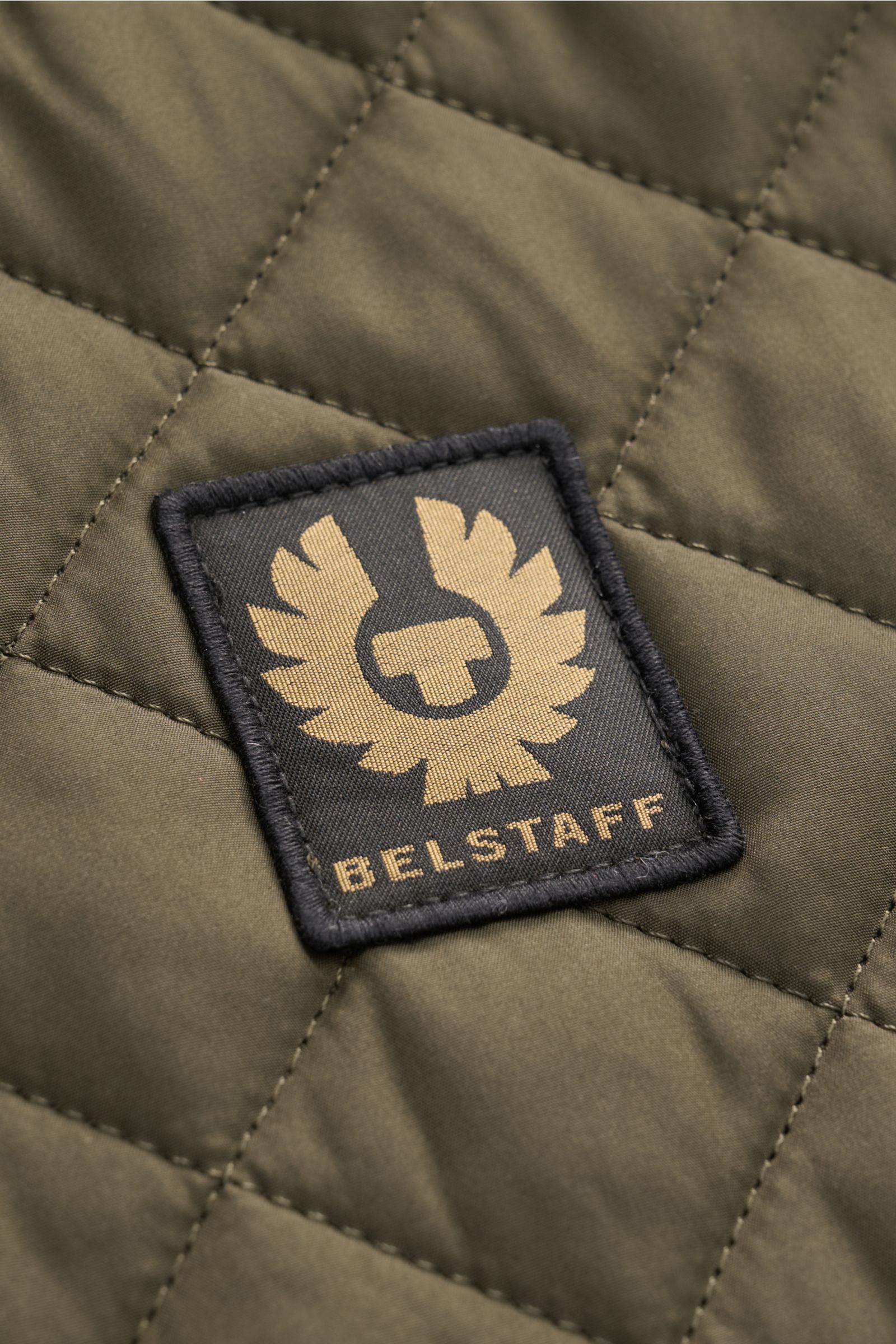 Belstaff Outdoorweste 'Icon' dark olive in Nahaufnahme, Steppweste aus Microfaser mit BELSTAFF-Weblabel, glattem Griff und Slim Fit.
