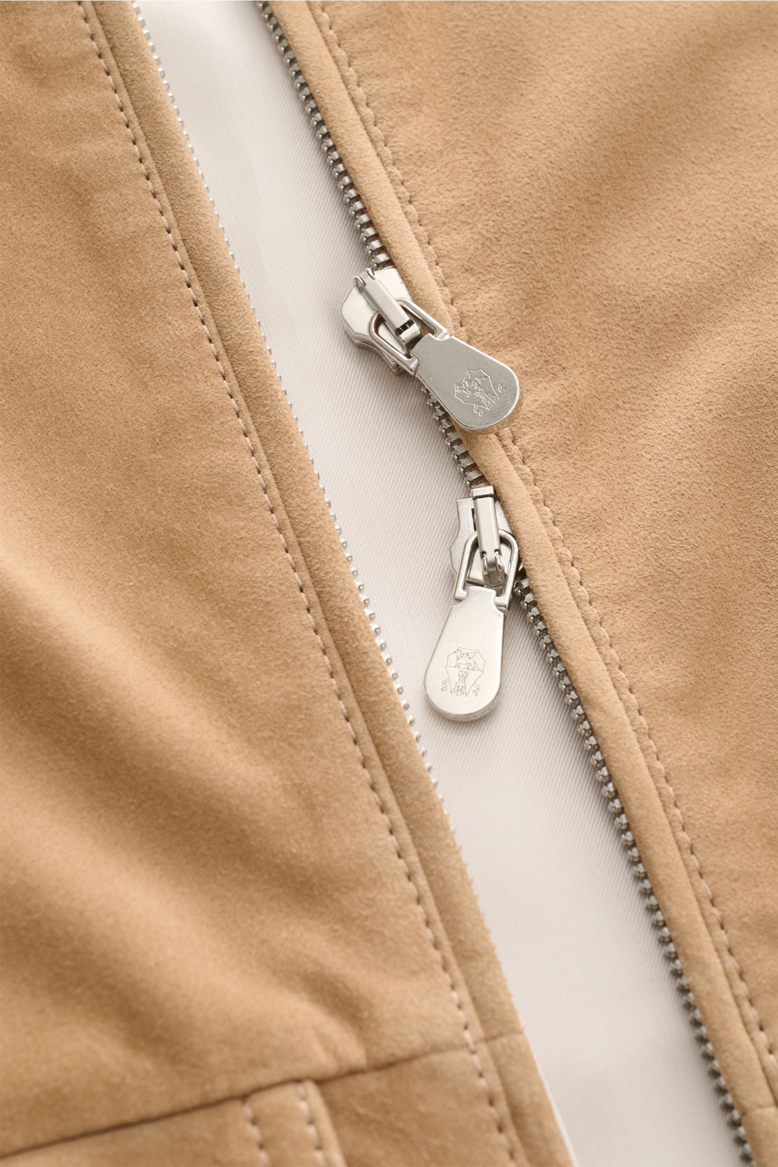 Close-up front view of the Brunello Cucinelli Outdoorweste camel showing the soft velours leather and two-way silver zipper pull with logo.

Description: Edles Übergangs-Essential: Die Velourslederweste von BRUNELLO CUCINELLI verleiht Outdoor-Looks eine l
