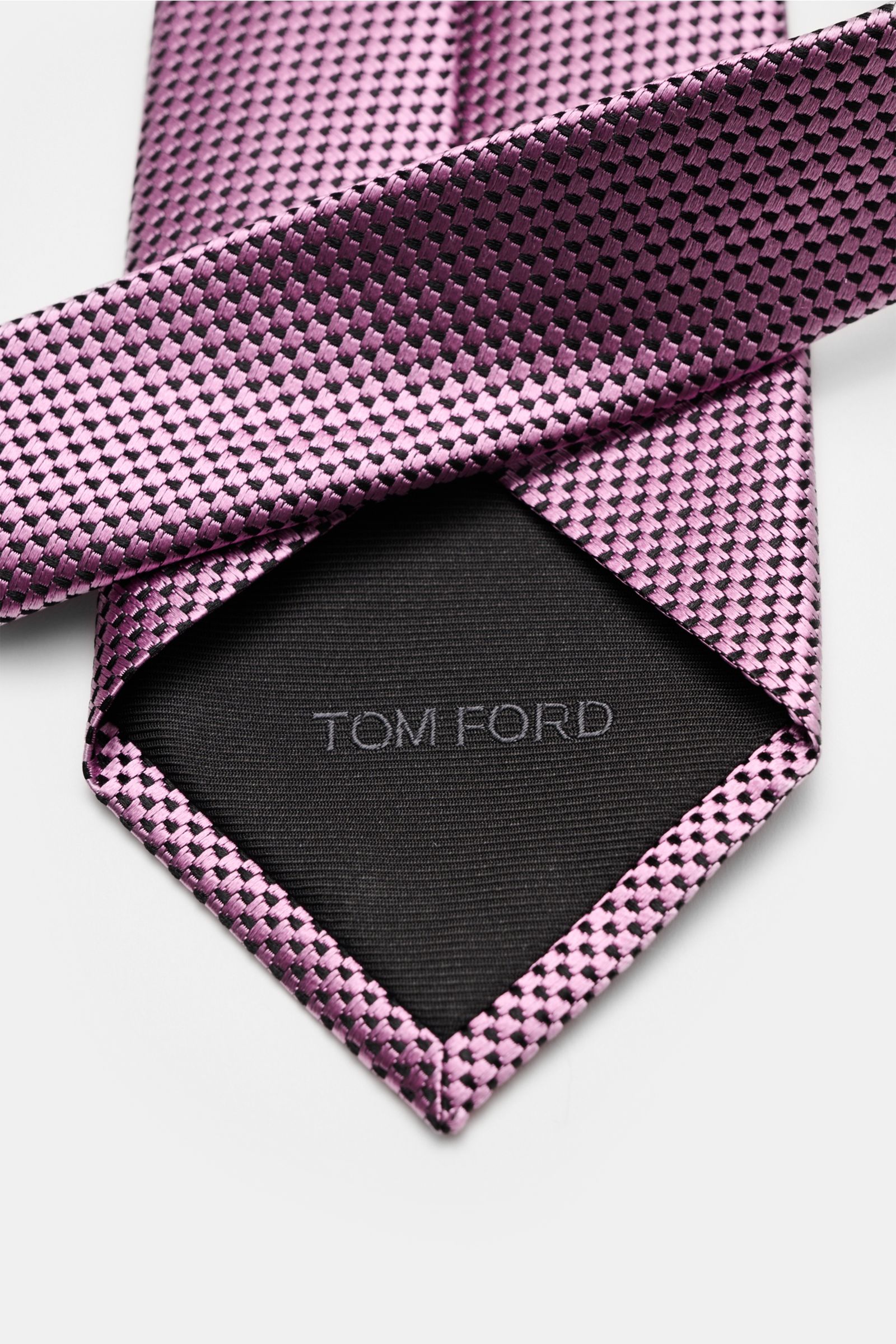 Tom Ford Seidenkrawatte rosé/schwarz gemustert shown from above, highlighting its pure silk, subtle shine, fine woven pattern, branded lining, made in Italy, 8 cm wide. Italienische Handwerkskunst: Dieser Krawatten-Klassiker von TOM FORD aus reiner Sei