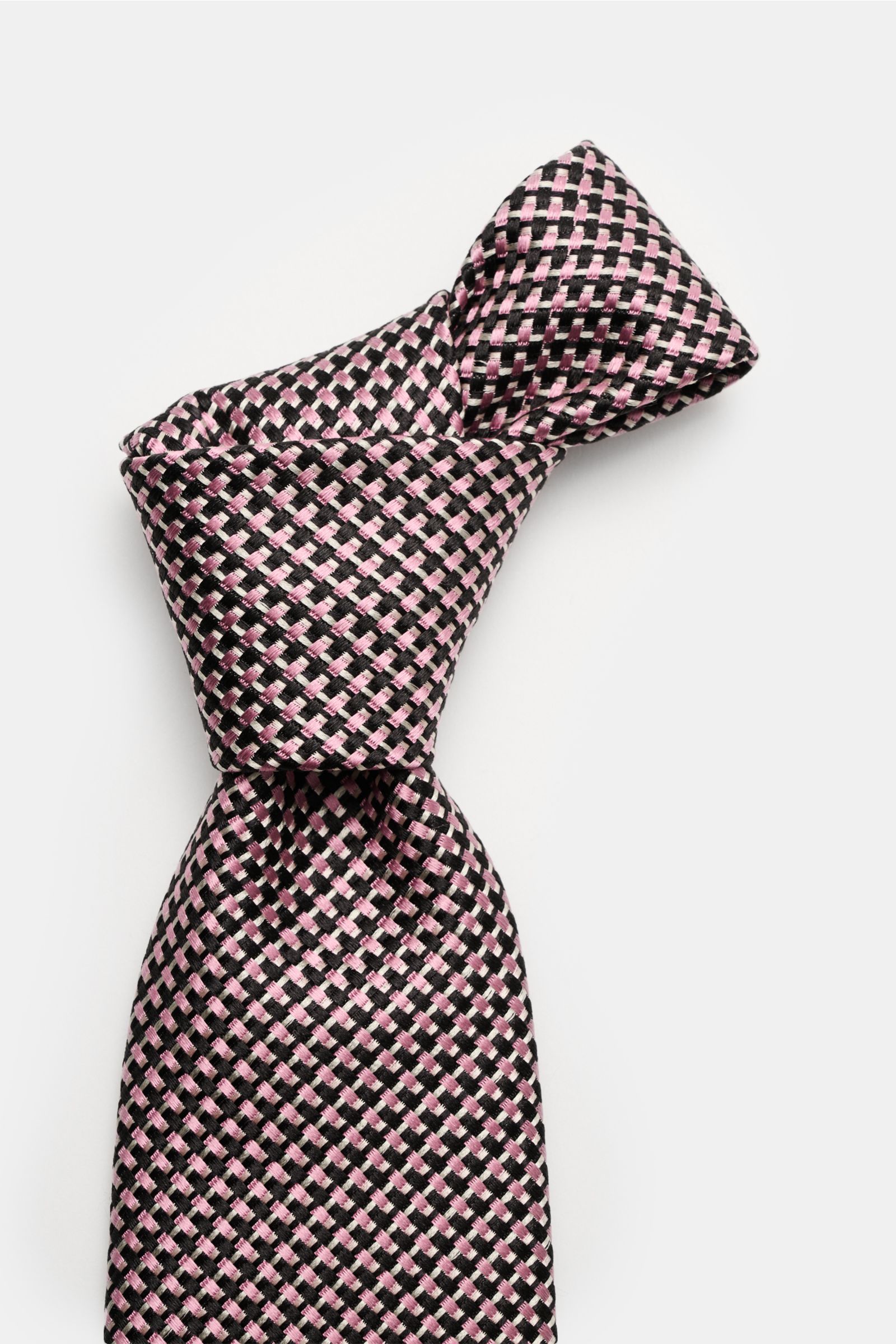 Top-down view of the Tom Ford Seidenkrawatte rosé/schwarz/grau gemustert, a pure silk tie with a subtle sheen and fine graphic woven pattern.

Italienische Handwerkskunst: Dieser Krawatten-Klassiker von TOM FORD aus reiner Seide vereint zeitlose Elegan