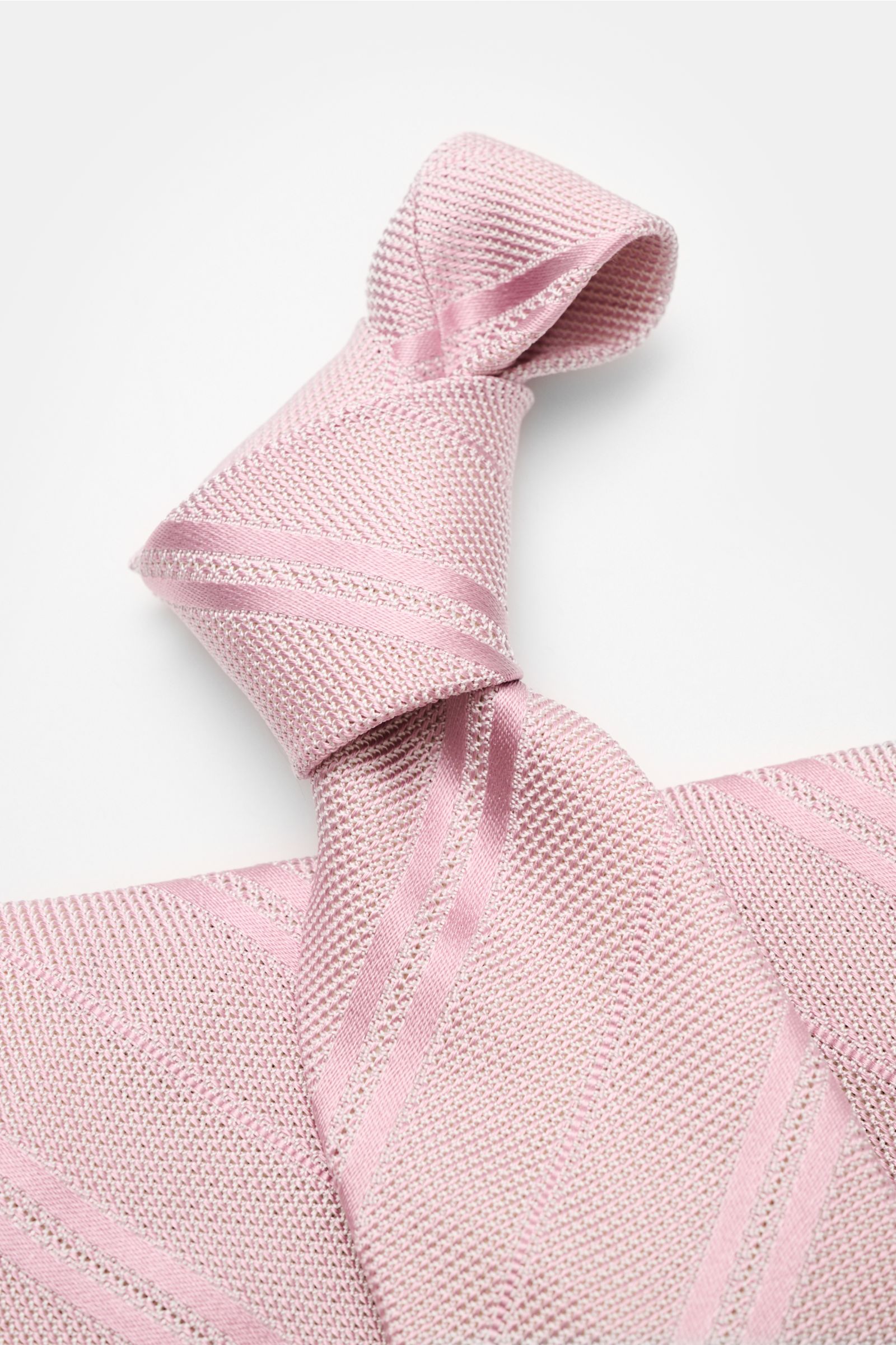 Close-up top-down view of the Tom Ford Seidenkrawatte altrosa/weiß gestreift, a pink and white striped silk tie with fine woven texture.

Italienische Handwerkskunst: Dieser Krawatten-Klassiker von TOM FORD aus reiner Seide vereint zeitlose Eleganz mit