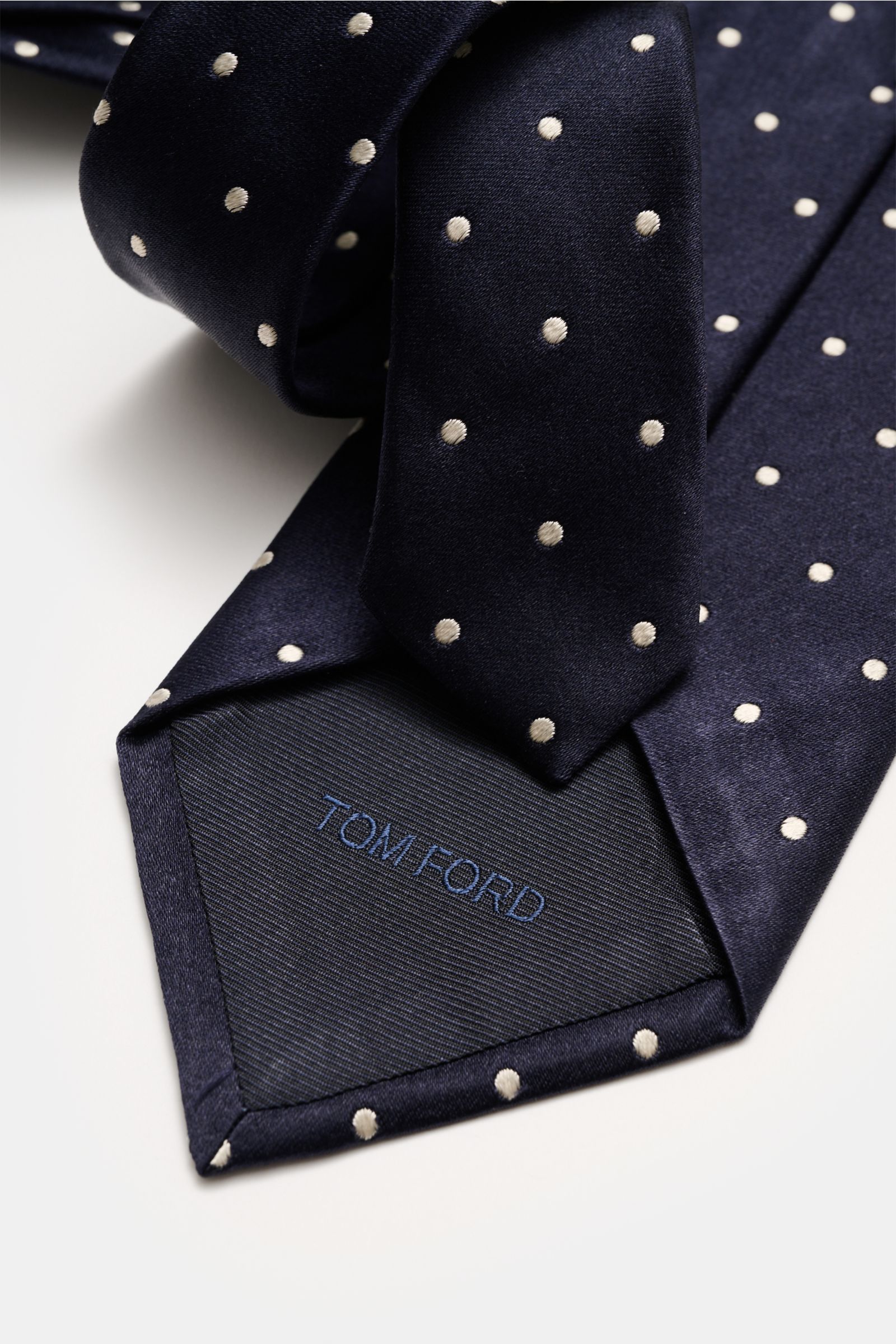Alt tag (125 characters max): Close-up front view of Tom Ford Seidenkrawatte navy/creme gepunktet silk tie with polka dots and logo stitching.

Additional description: 
Zeitloser Stil mit luxuriöser Note: Die Seidenkrawatte von TOM FORD überzeugt als e