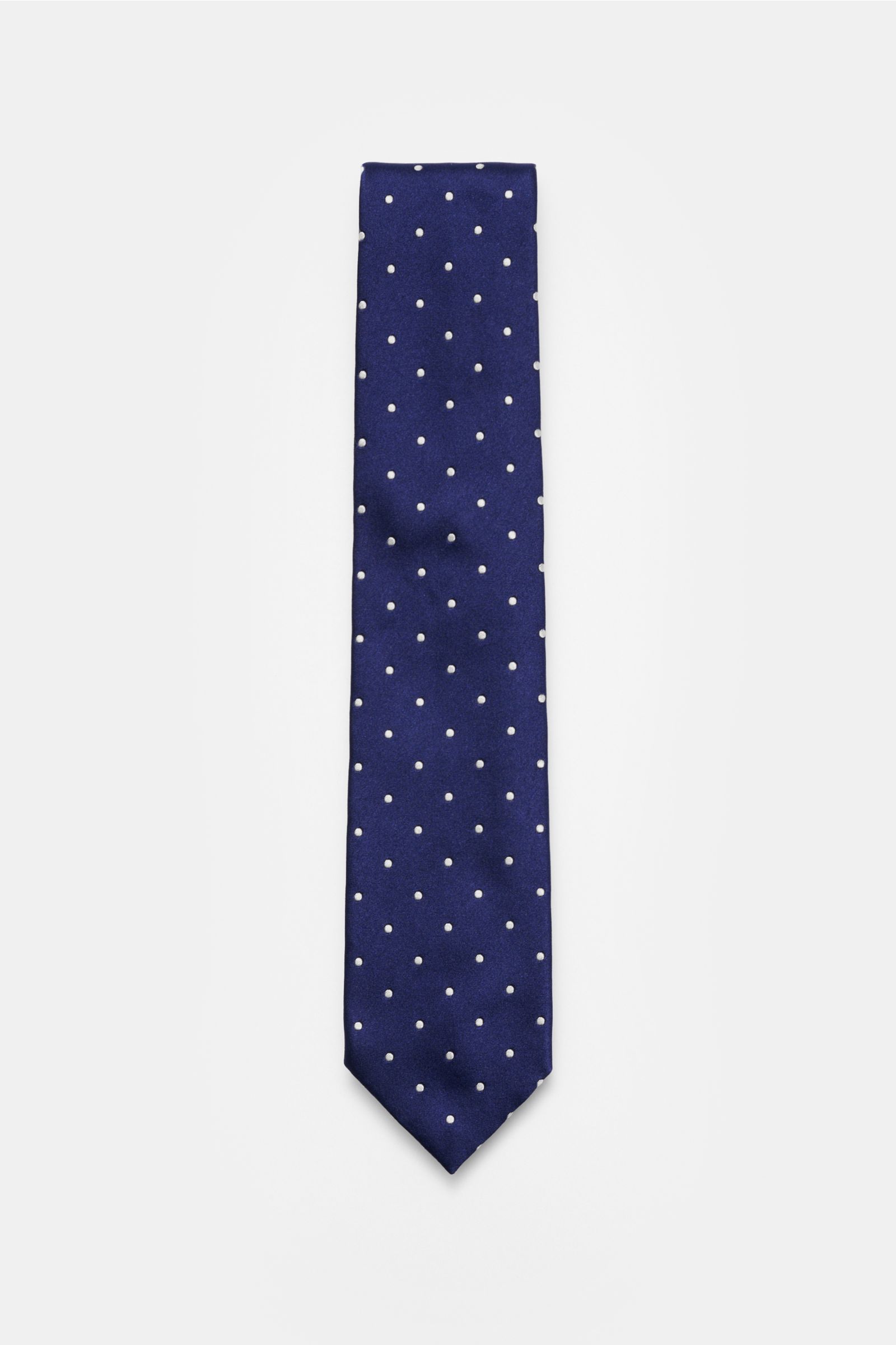 Top-down view of the Tom Ford Seidenkrawatte dunkelblau/creme gepunktet silk tie with white polka dots on dark blue background, showcasing its elegant design.

Zeitloser Stil mit luxuriöser Note: Die Seidenkrawatte von TOM FORD überzeugt als elegantes 