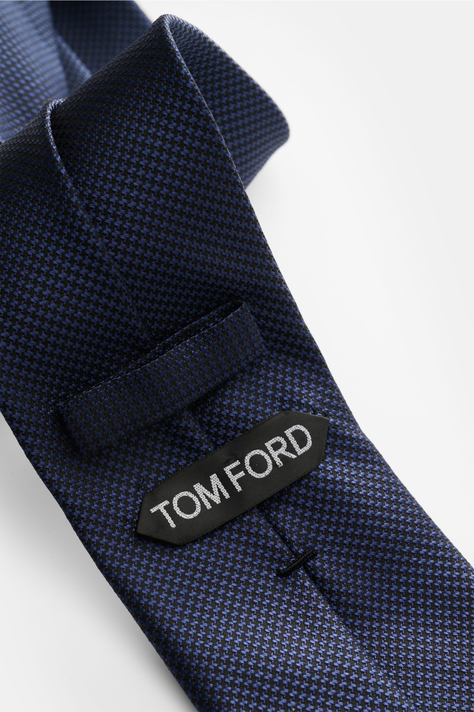 Tom Ford Seidenkrawatte dunkelblau/schwarz gemustert mit zeitlosem Hahnentritt, Logo-Stitching, reine Seide, dezent glänzend, Detailansicht.