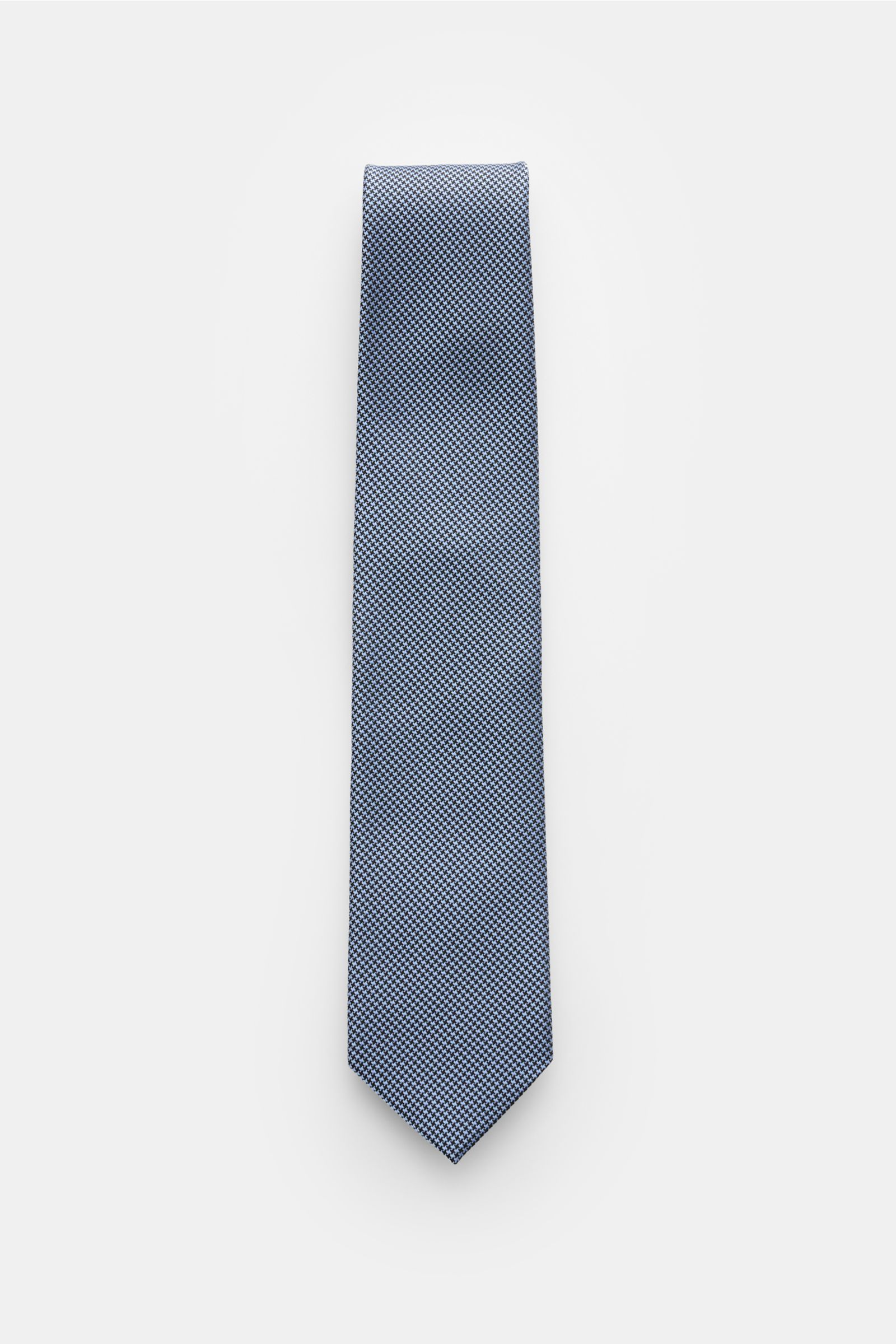 Tom Ford Seidenkrawatte hellblau/schwarz gemustert, elegante Perspektive von oben, reine Seide, dezenter Glanz, Hahnentrittmuster, Logo-Stitching, made in Italy, 8 cm breit.