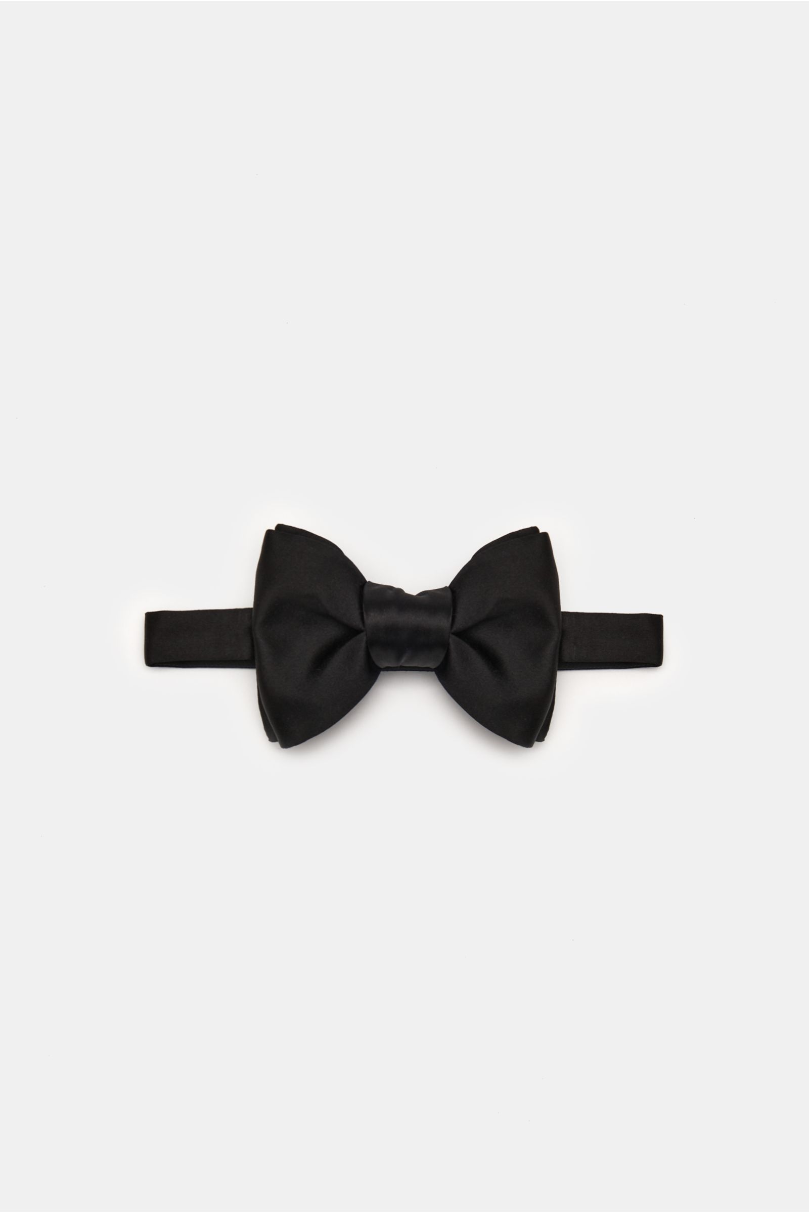 Top-down view of a tied Tom Ford Silk bow tie black made of pure silk with a slight satin sheen, width approx. 10.5 cm, classic formal look. 

This elegant bow tie from TOM FORD is made of luxurious silk satin and adds the perfect finishing touch for a
