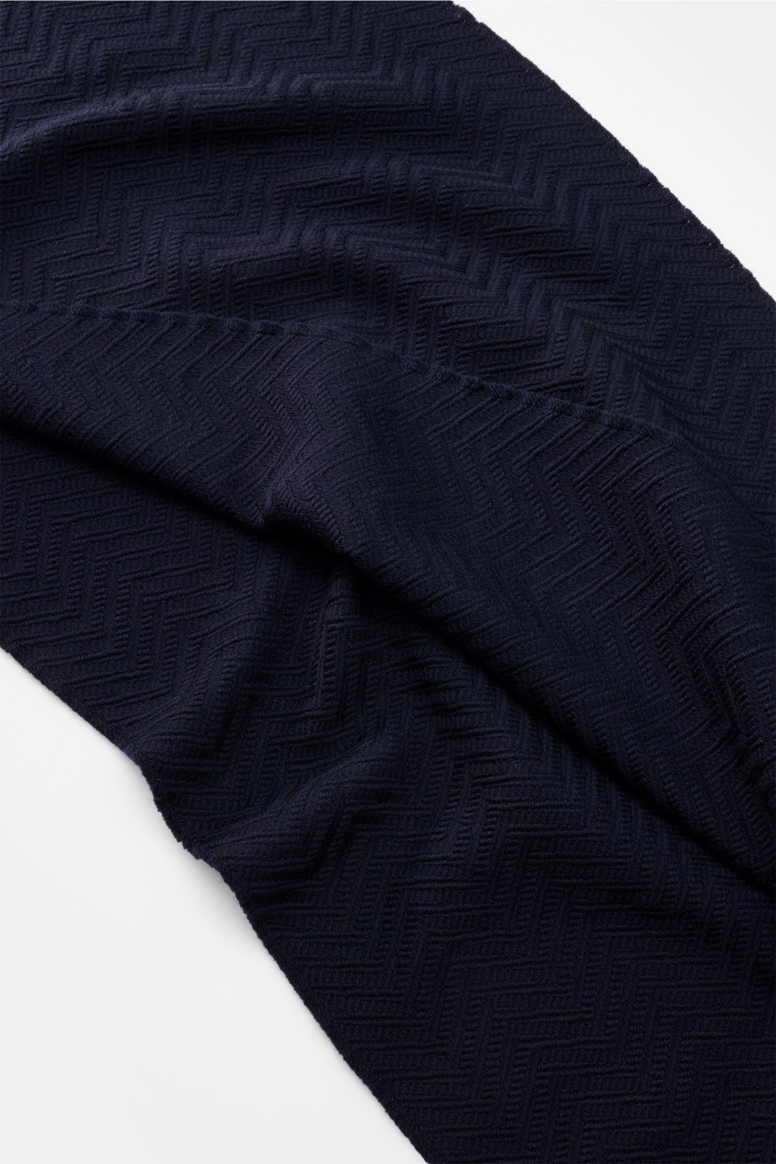 Emporio Armani Schal navy shown from a top-down view, highlighting its tonal herringbone weave, soft wool texture, logo stripe, and narrow fringed edges. Italienische Eleganz für jeden Tag: Der edle Schal von EMPORIO ARMANI aus reiner Wolle überzeugt mit 