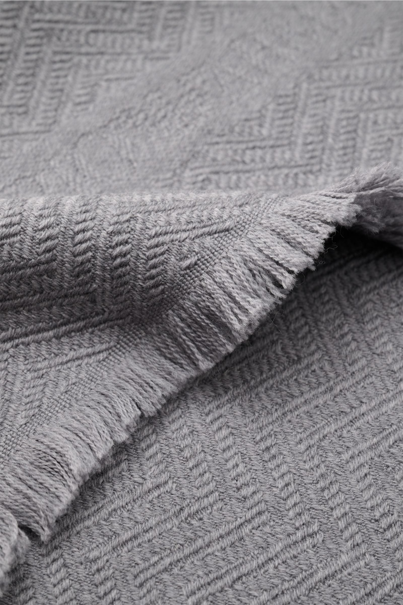 Emporio Armani Schal grau, Nahaufnahme von schmalem Fransensaum und tonaler Fischgratstruktur aus weicher reiner Wolle.