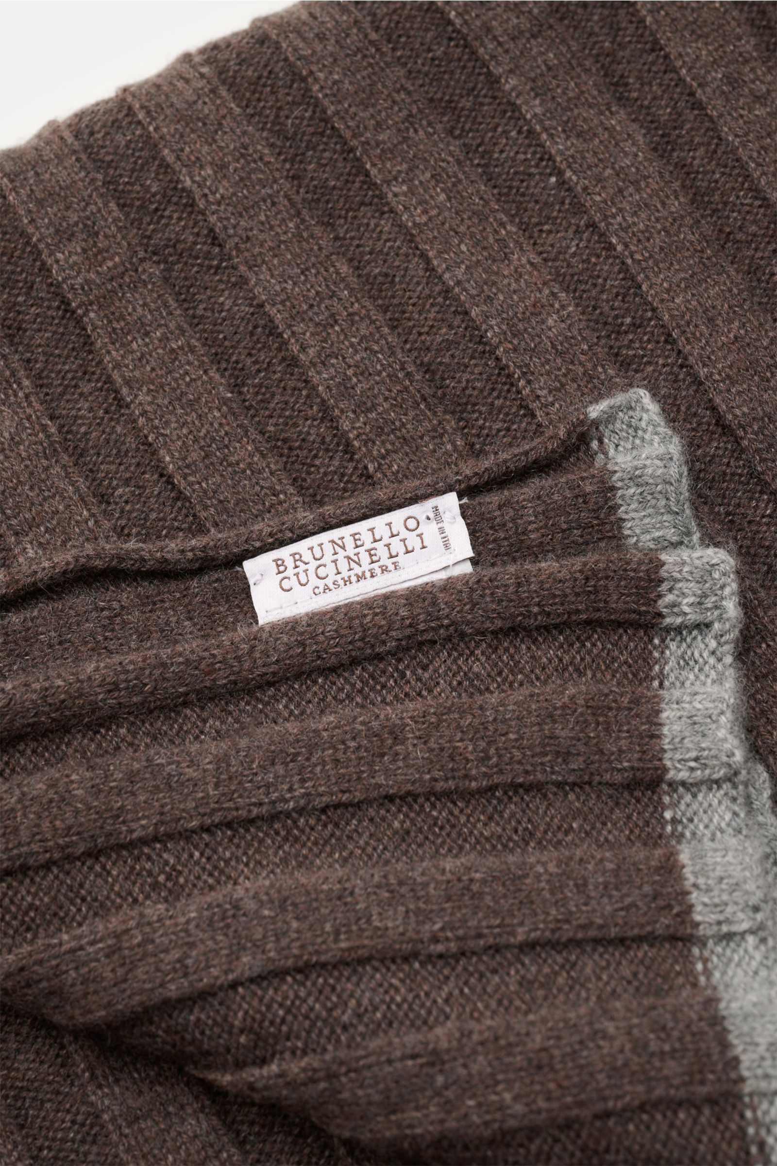 Close-up top view of Brunello Cucinelli Cashmere Schal braun meliert with ribbed texture, soft fabric, and contrasting gray edges, label visible.

Ein edler Allrounder für die kühle Saison: Dieser Schal von BRUNELLO CUCINELLI aus reinem Cashmere überze