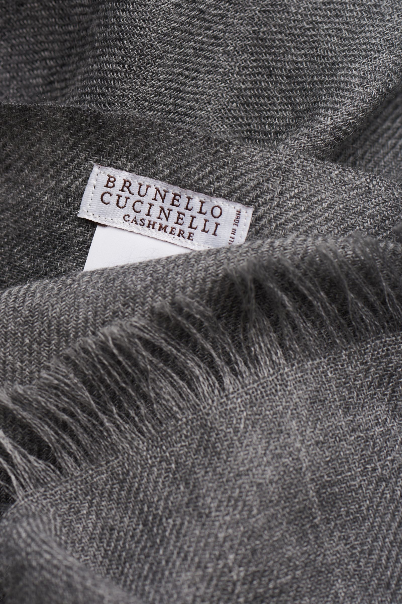Nahaufnahme des Brunello Cucinelli Schal navy/grau aus Cashmere und Seide, Bicolor-Design, weicher Griff, schmaler Fransensaum, Detailansicht von oben.