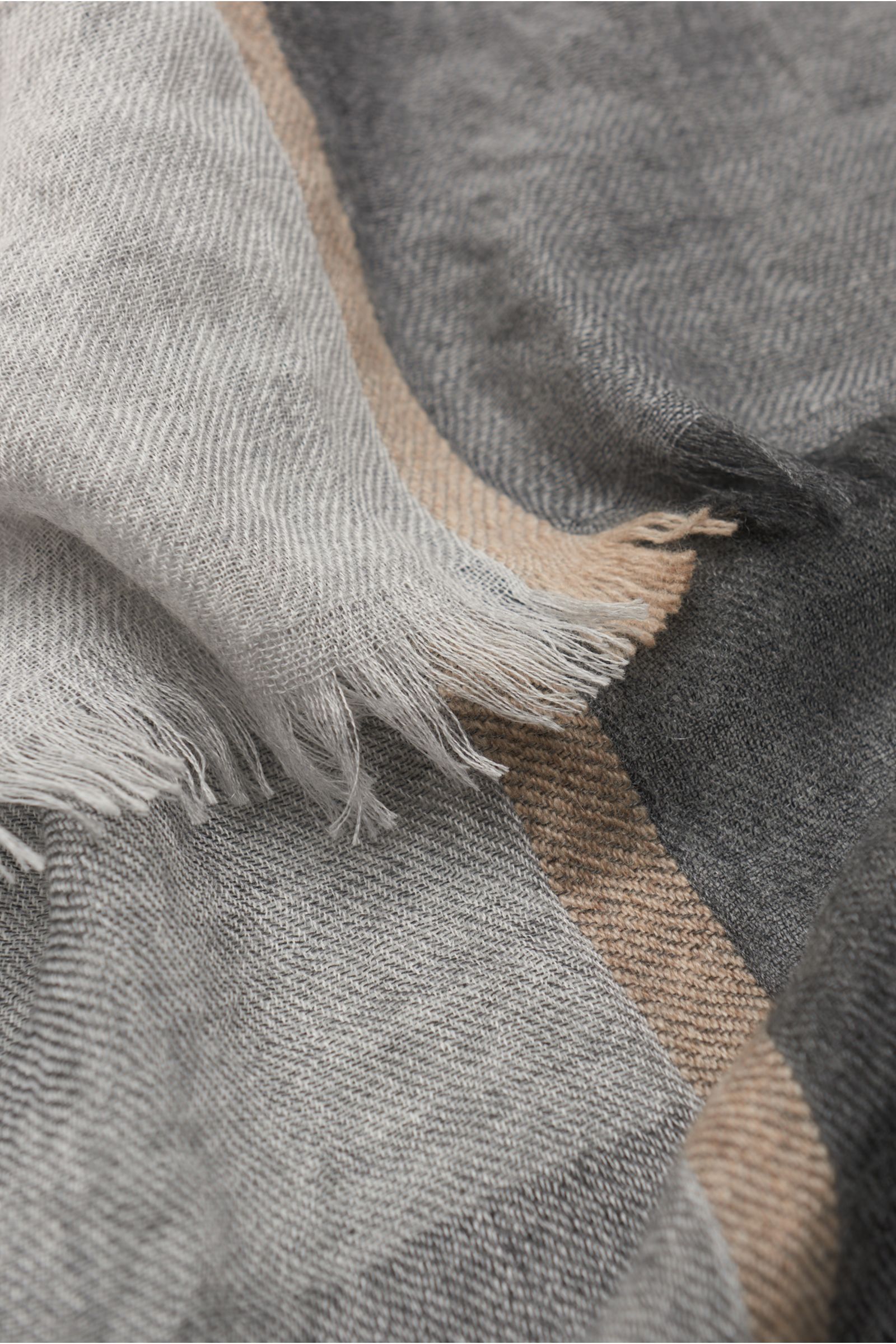Nahaufnahme des weichen Brunello Cucinelli Schal grau/dunkelgrau im Bicolor-Design aus Cashmere und Seide mit schmalem Fransensaum.