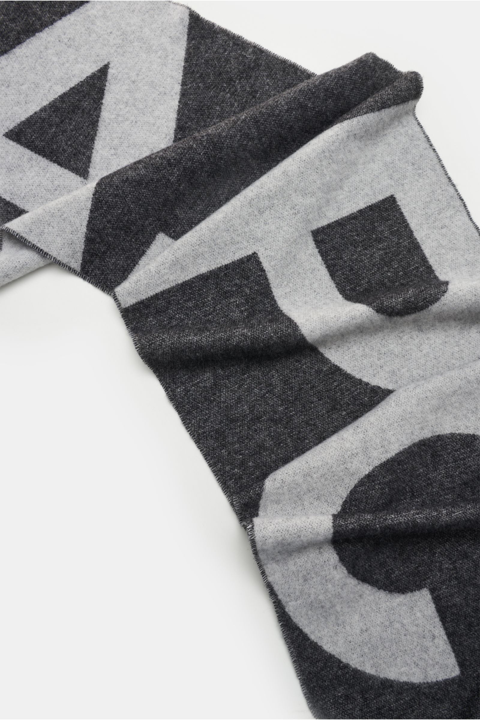 A.P.C. Schal schwarz/offwhite aus Wolle und Microfaser mit weichem Griff, Doubleface-Design, großem Logo und Fransensaum, liegend fotografiert.