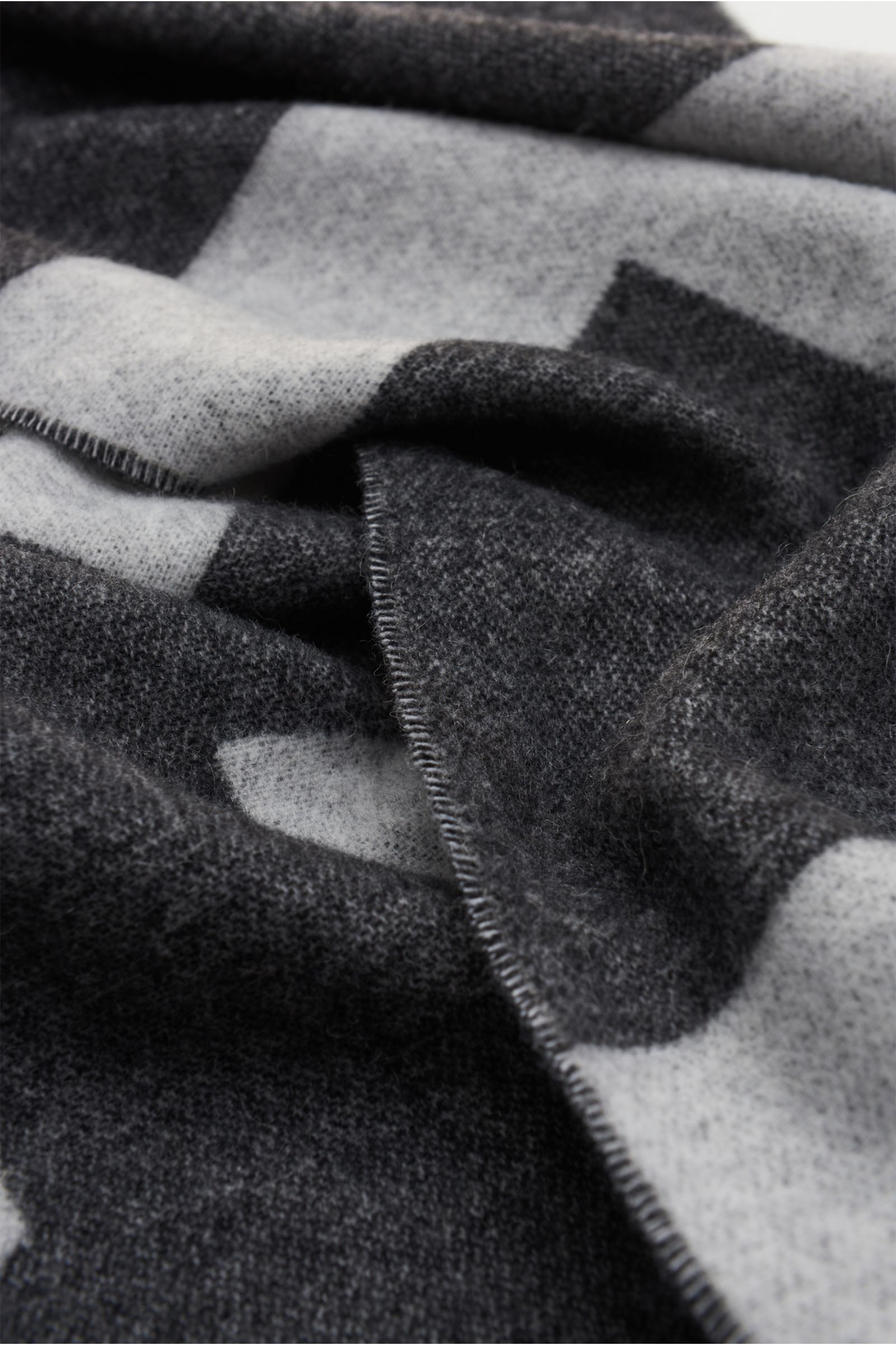 A.P.C. Schal schwarz/offwhite aus Wolle und Microfaser, weicher Griff, Doubleface-Design, nahaufnahme mit Fransensaum, Maße ca. 205x38 cm, großflächiges Logo.