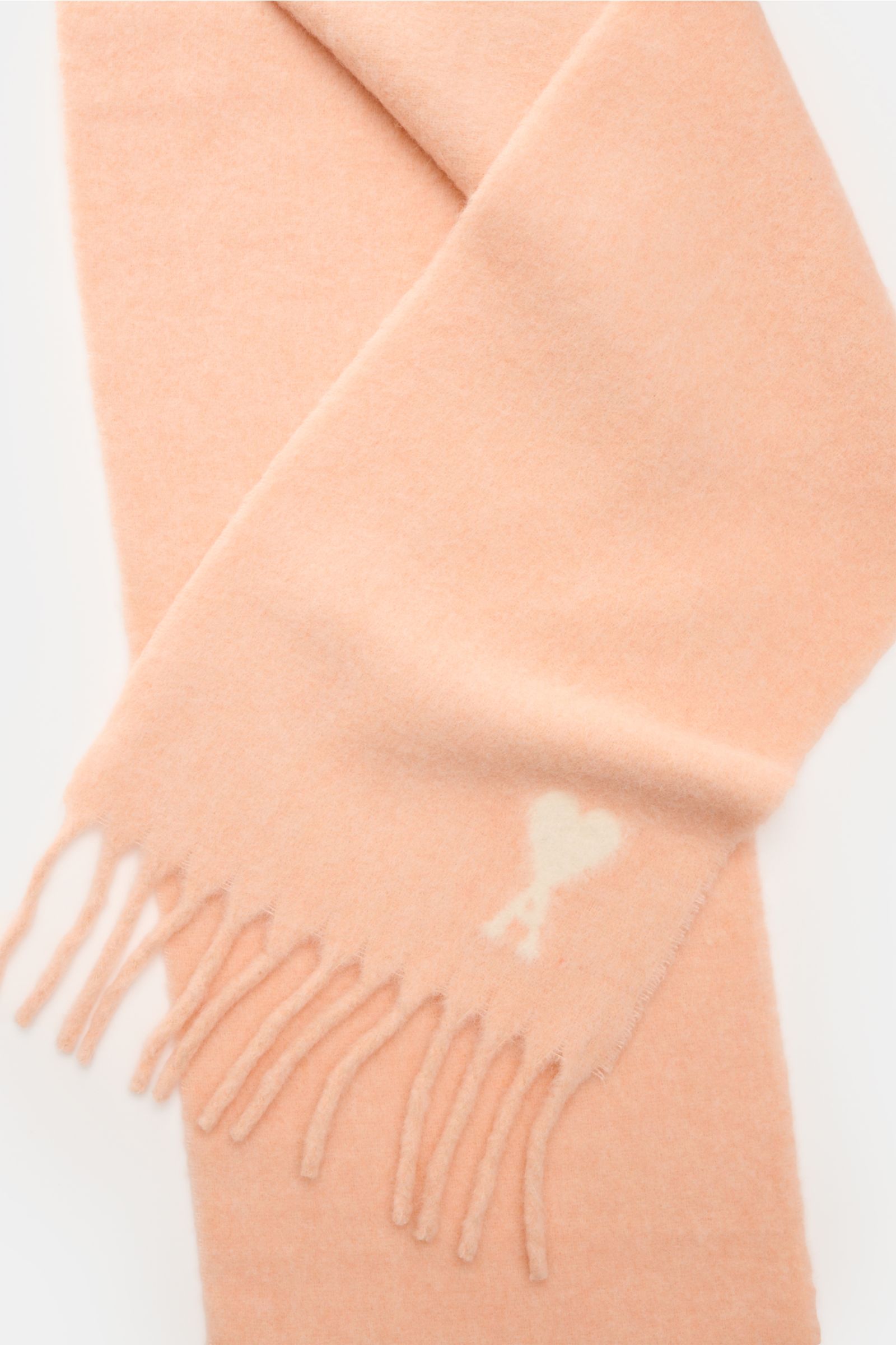 Close-up top view of Ami Paris Scarf rose in soft alpaca wool blend, showing fringed edge and signature 'Ami de Cœur' logo.

A minimalist classic: This long scarf by AMI PARIS in a super soft alpaca wool blend with signature monogram perfectly compleme