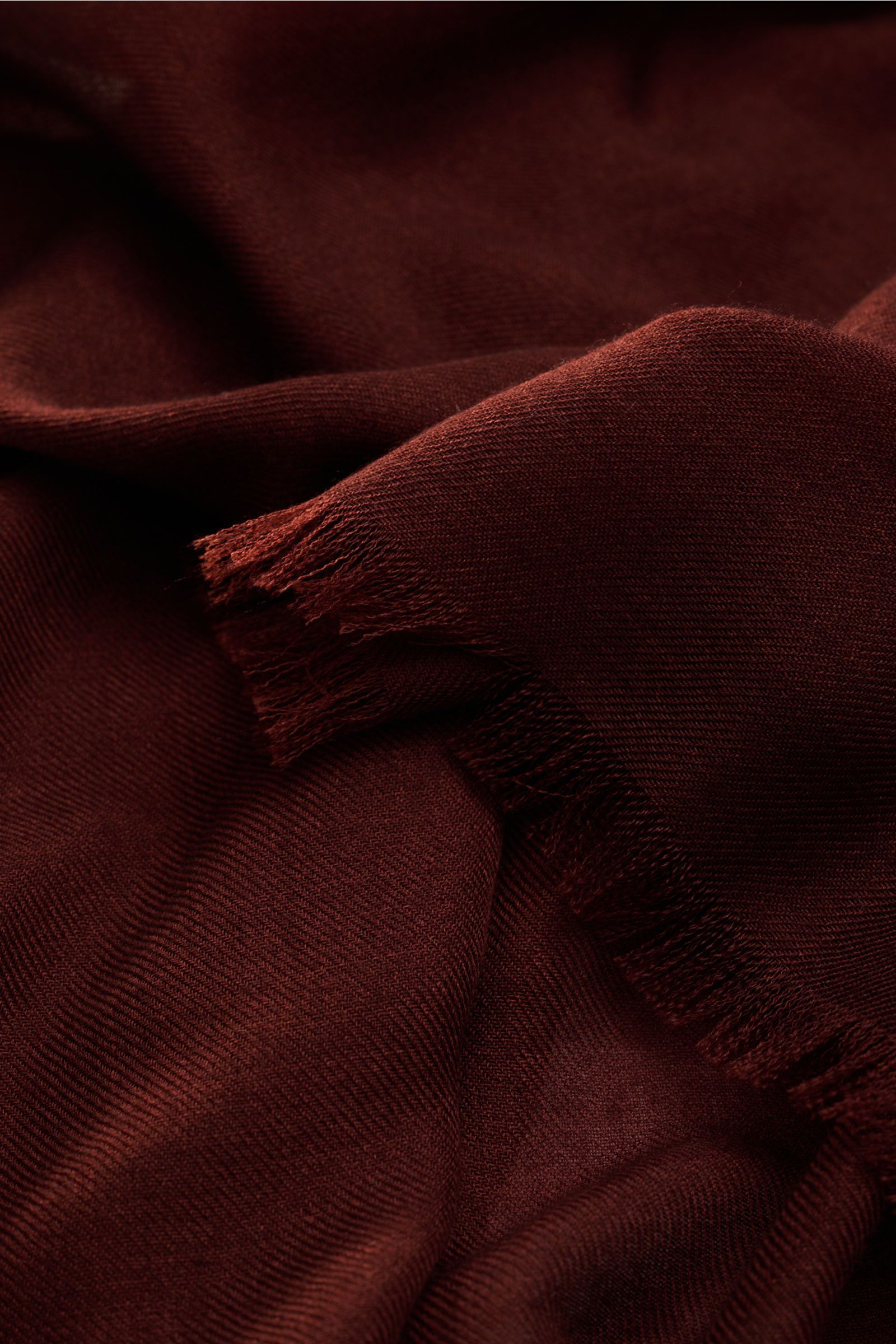 Close-up front view of Colombo Schal rotbraun in rich reddish-brown, showing soft texture, narrow fringed edges, rolled hems, made of fine cashmere and silk, very light quality, approx. 196 cm x 70 cm.