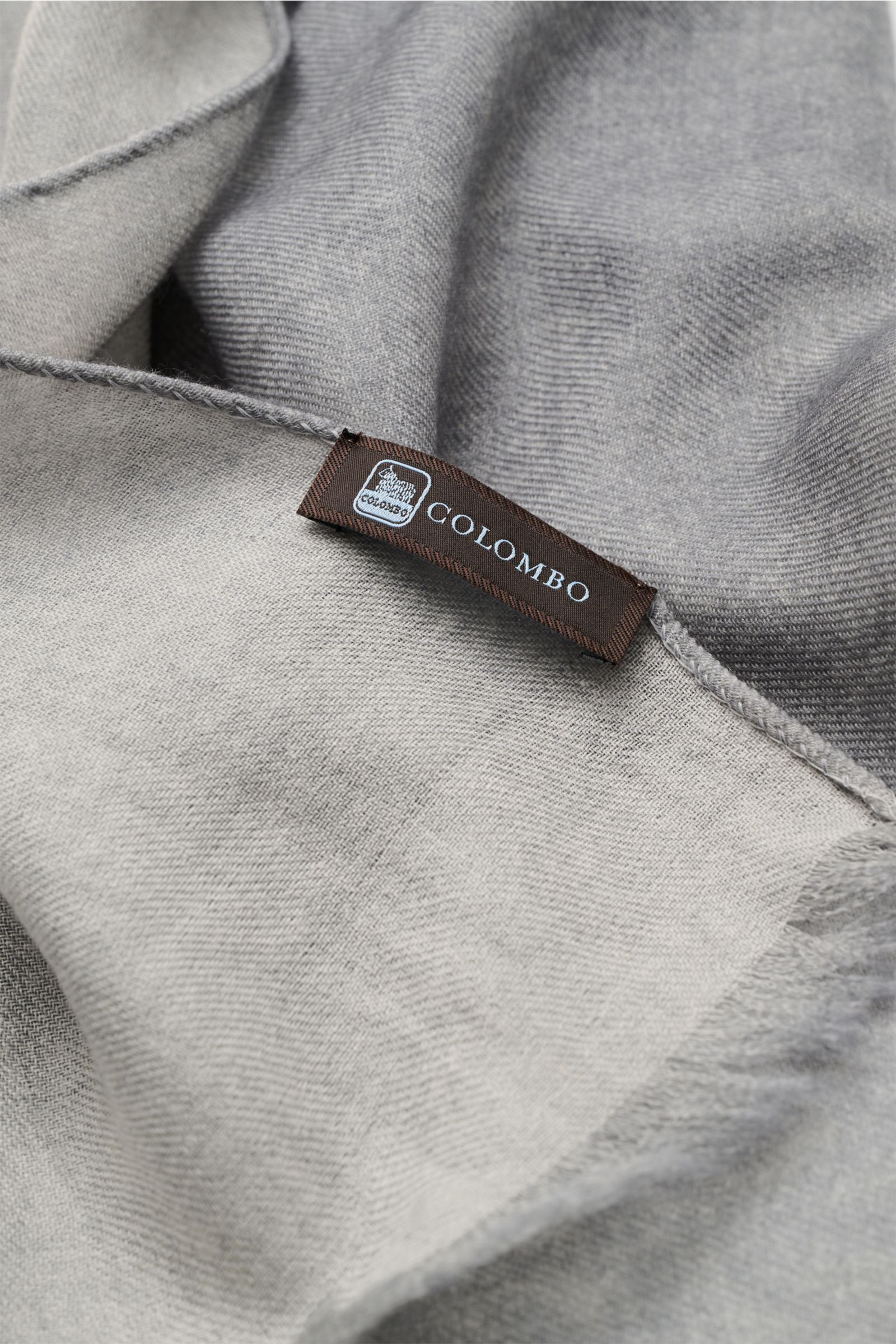 Close-up top view of the Colombo Scarf grey showing fine cashmere and silk blend fabric with soft feel, very lightweight, narrow fringed edges, dimensions approx. 196 cm x 70 cm.