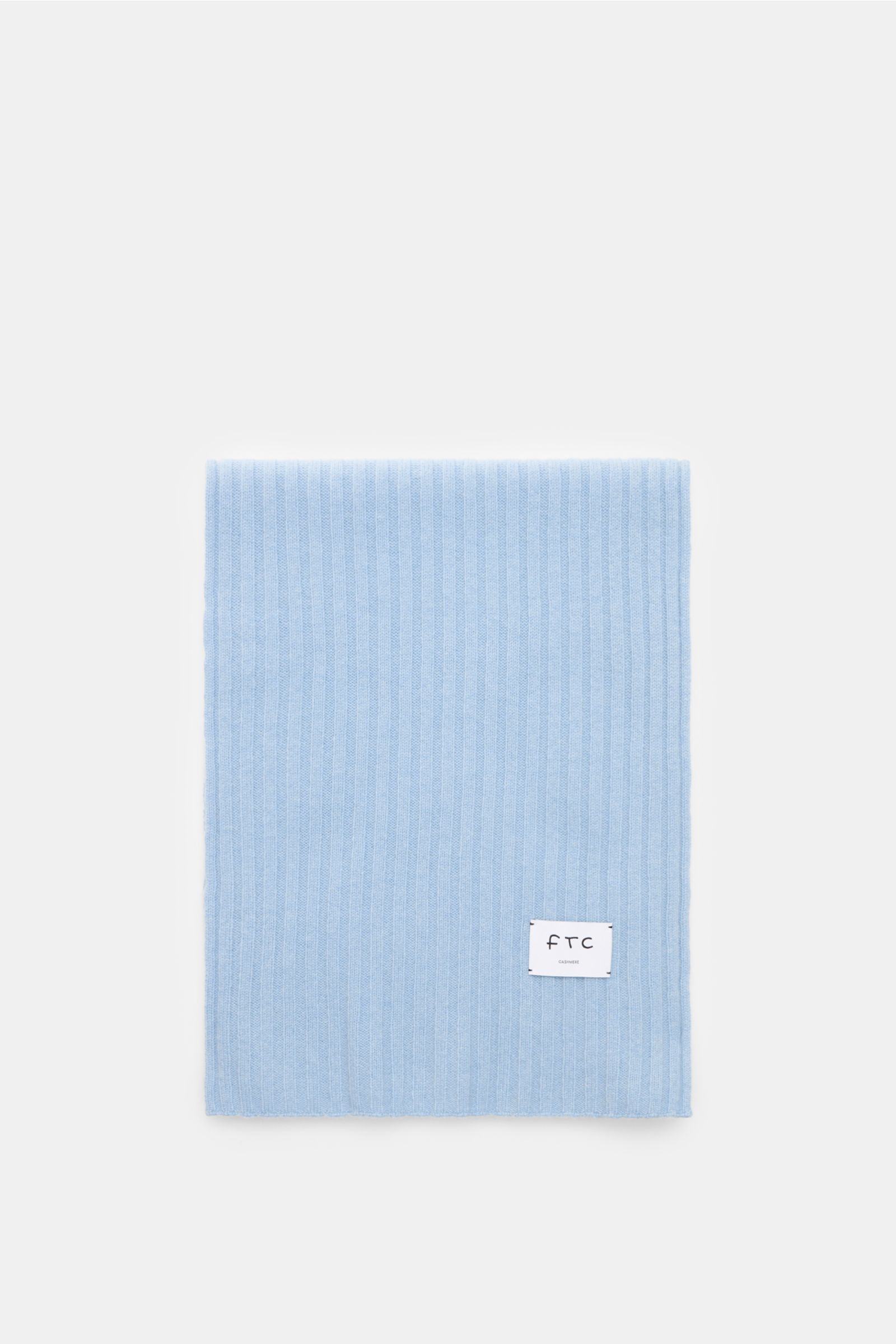 FTC Cashmere Schal hellblau, von oben fotografiert, zeigt breites Rippstrickmuster, weichen Griff, Weblabel und Maße ca. 185x36 cm, reiner Fair Trade Cashmere.