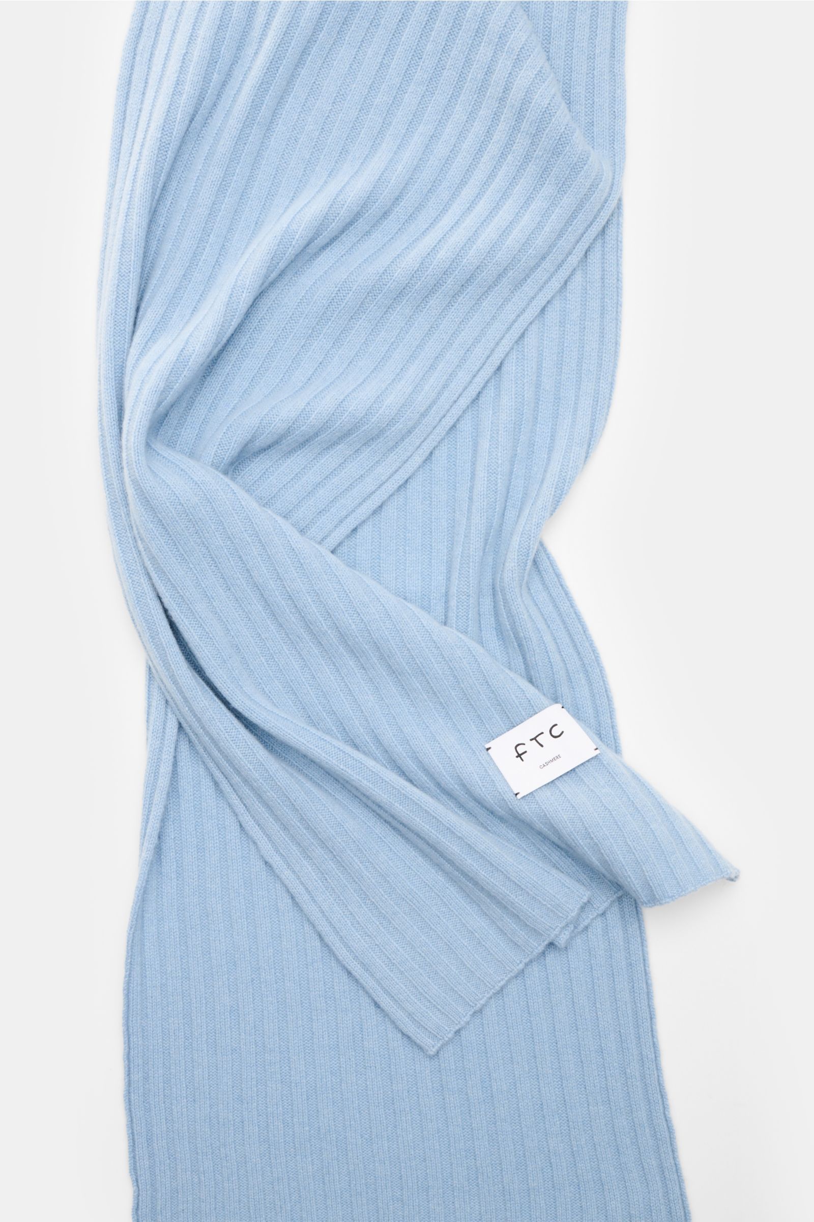 FTC Cashmere Schal hellblau aus reinem Fair Trade Cashmere mit breitem Rippstrickmuster, weichem Griff und großem Weblabel, frontal fotografiert.