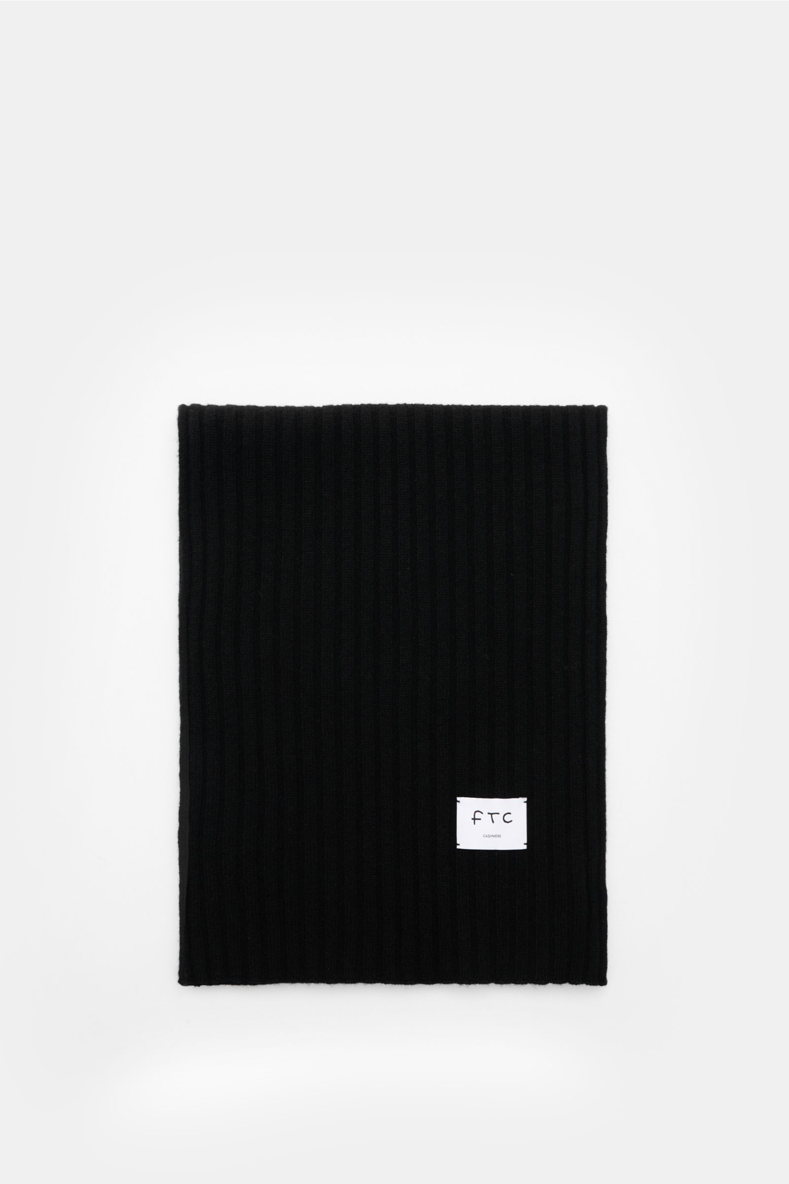 FTC Cashmere Schal schwarz, von oben fotografiert, zeigt breites Rippstrickmuster, weichen Griff, großes Weblabel, Maße ca. 185x36 cm.