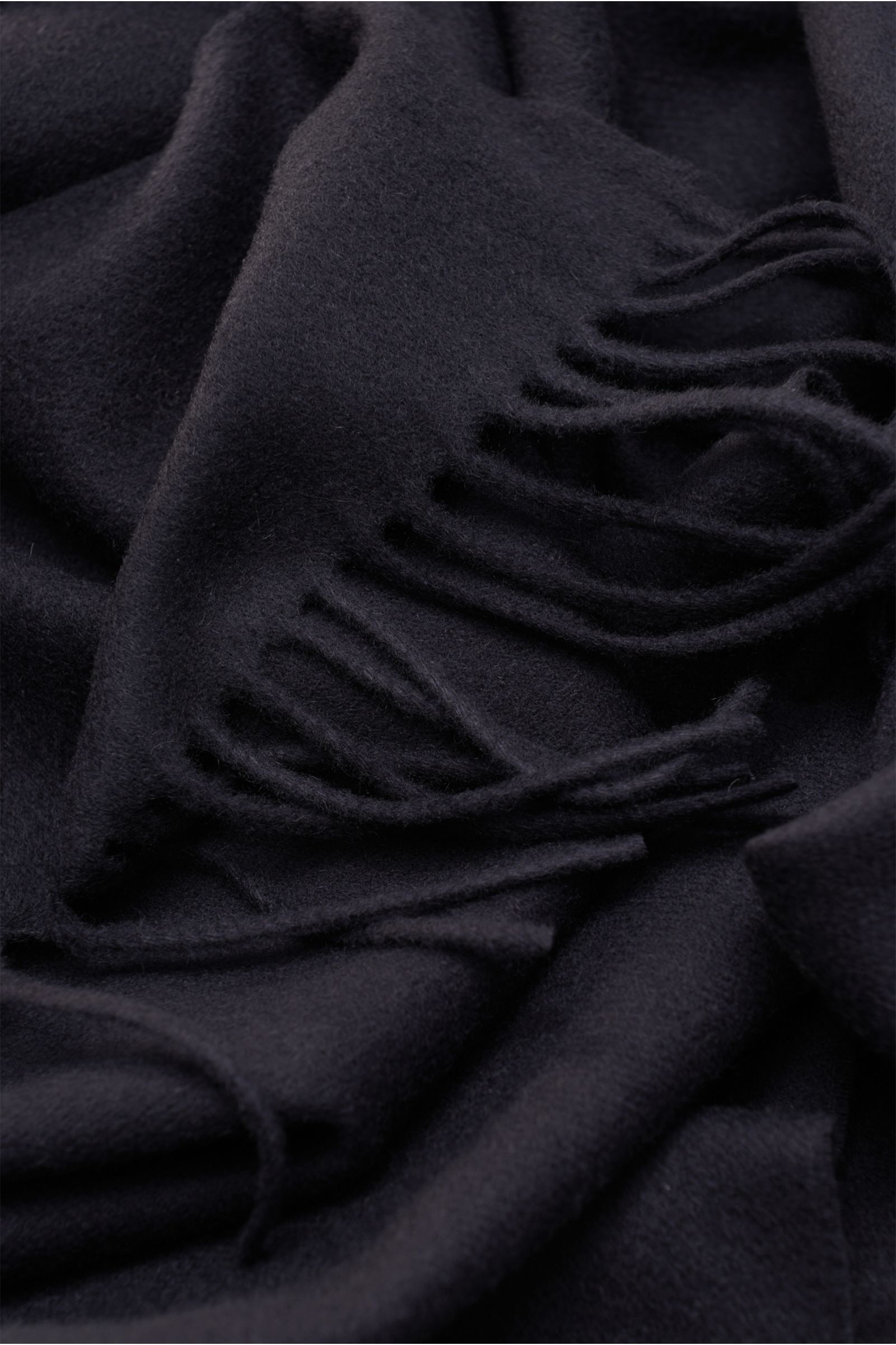 Close-up photo from above of the Moorer Cashmere scarf 'Kade' navy, showing its soft texture and fringed edges on both sides. Pure cashmere, soft touch, fringed edge on both sides, dimensions: approx. 172 cm x 35 cm.