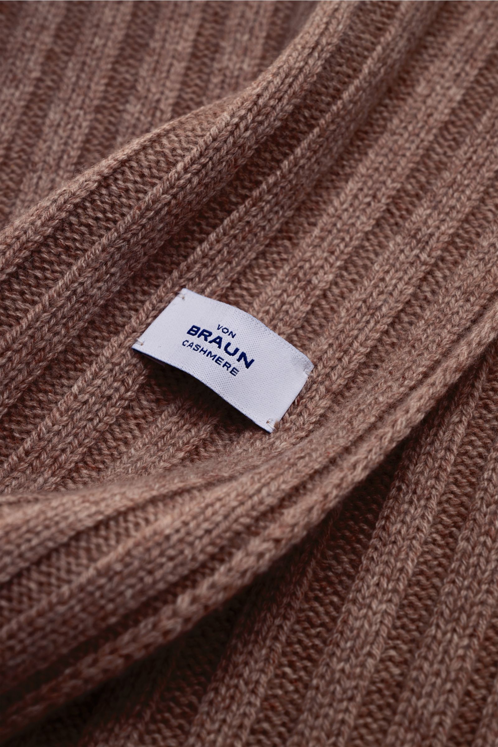 Nahaufnahme aus schräger Perspektive des von Braun Cashmere Schal braun meliert mit klassischem Rippstrick-Design und feinem Strickbild, weich und lang.