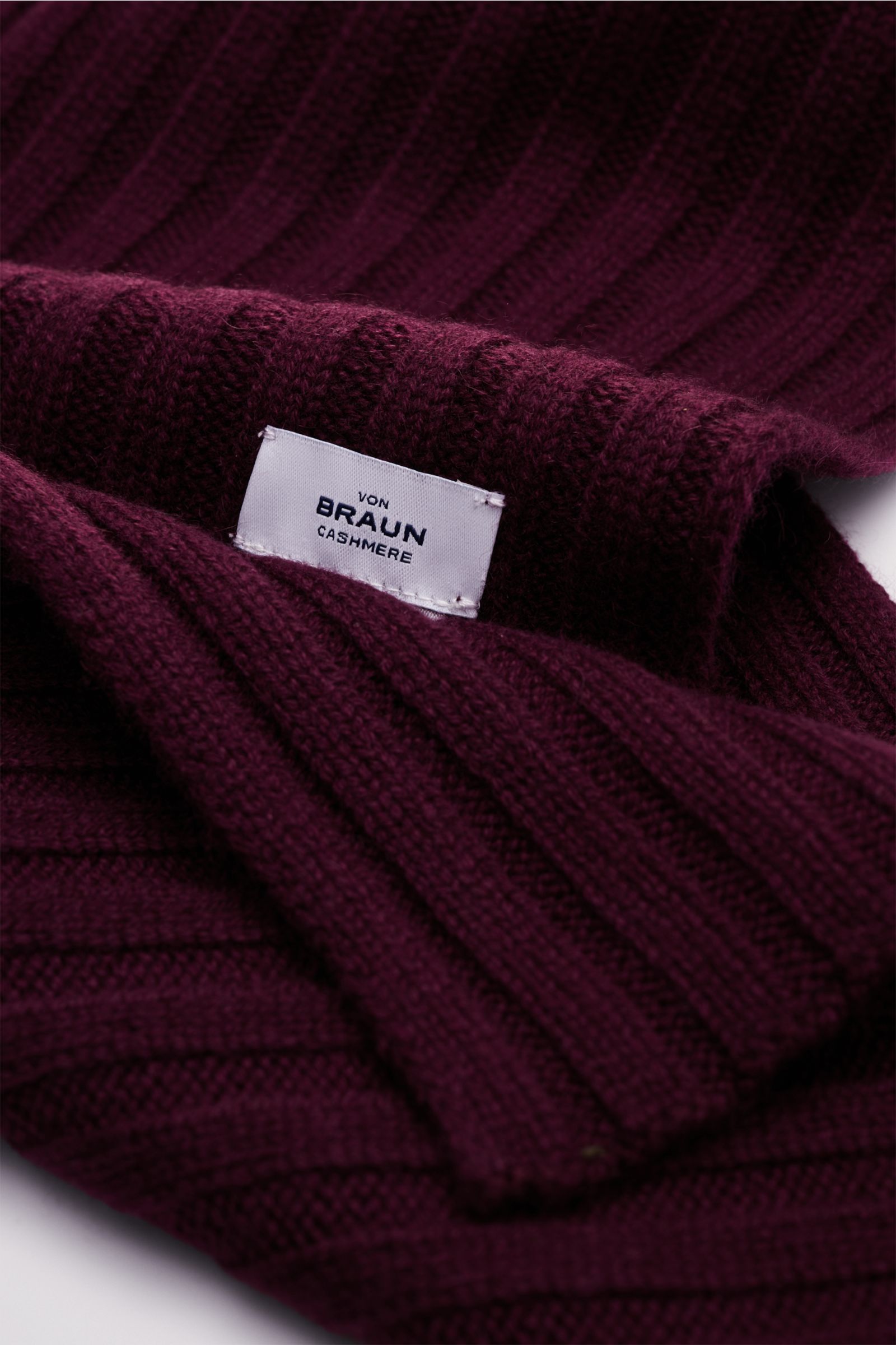 Nahaufnahme des von Braun Cashmere Schal bordeaux aus reinem mongolischem Cashmere mit klassischem Rippstrick-Design und weichem Griff, liegend fotografiert.