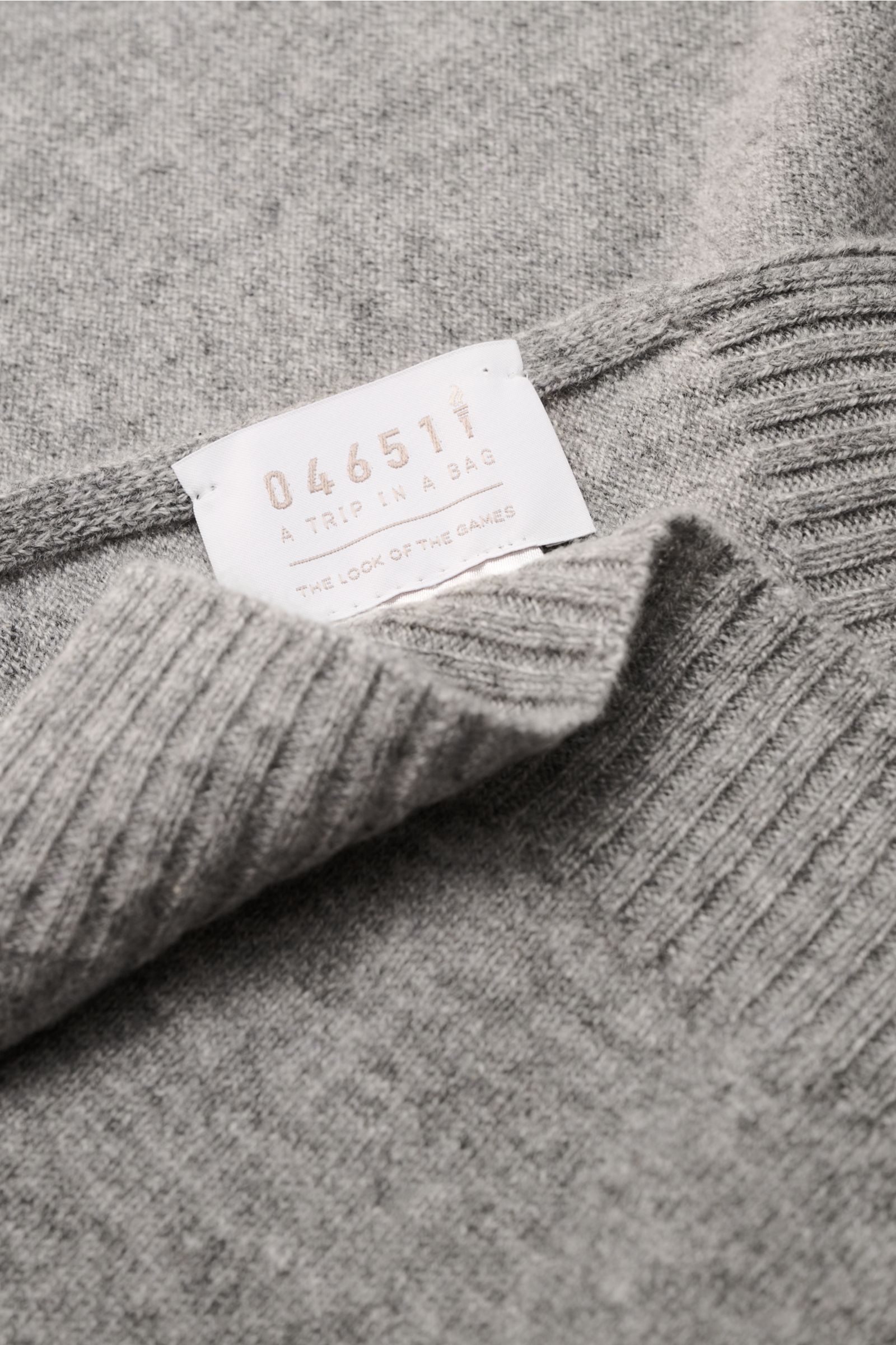 Nahaufnahme des 04651/ A trip in a bag Cashmere Schal creme, weicher reiner Cashmere mit Rippstrick-Kanten, von oben fotografiert.