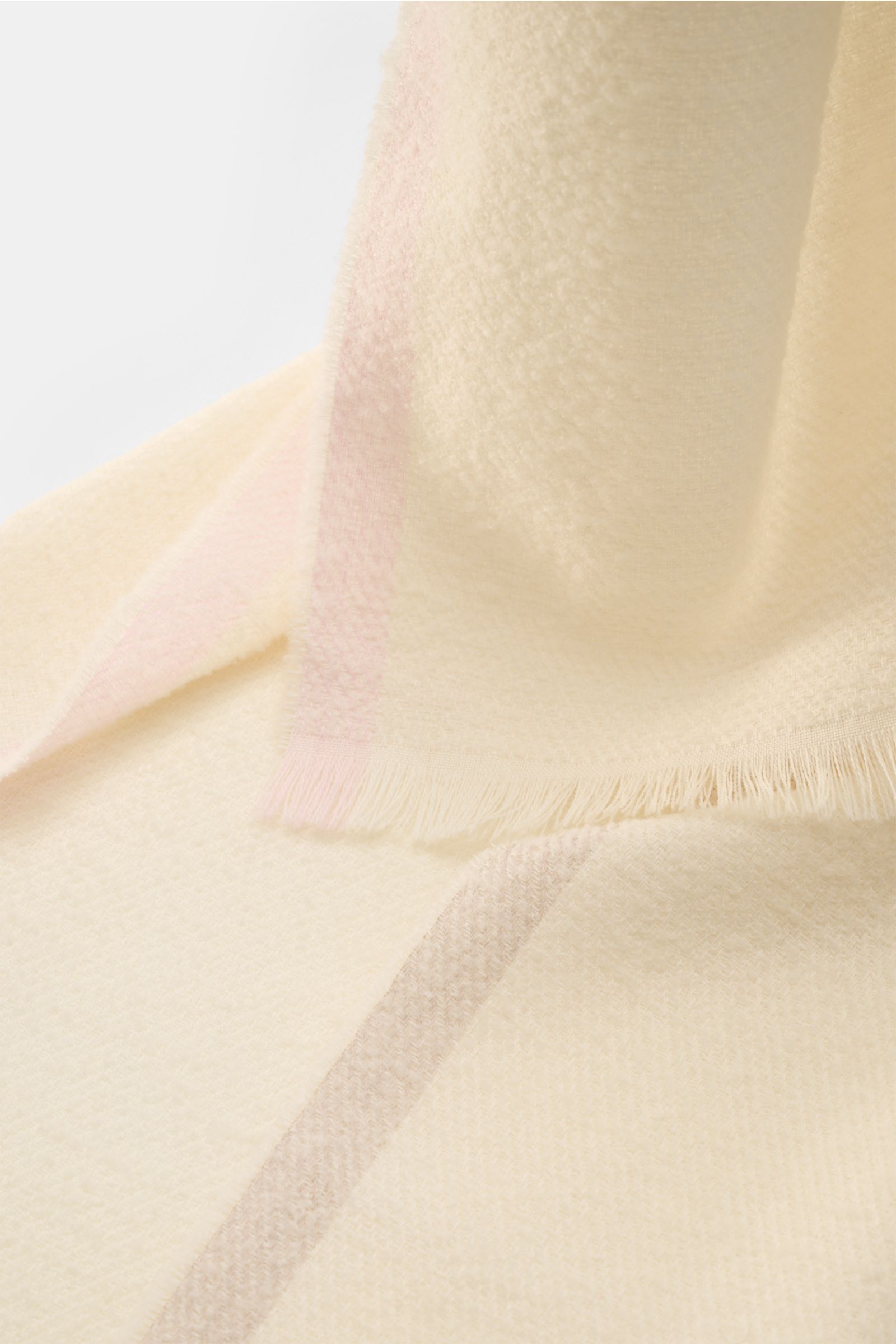 Cream-colored 04651/ A trip in a bag Scarf cream shown from a close-up angled top-down view, highlighting its soft bouclé virgin wool blend with narrow fringed edge. Luxurious comfort for winter: Fine virgin wool material makes this scarf in bouclé look f