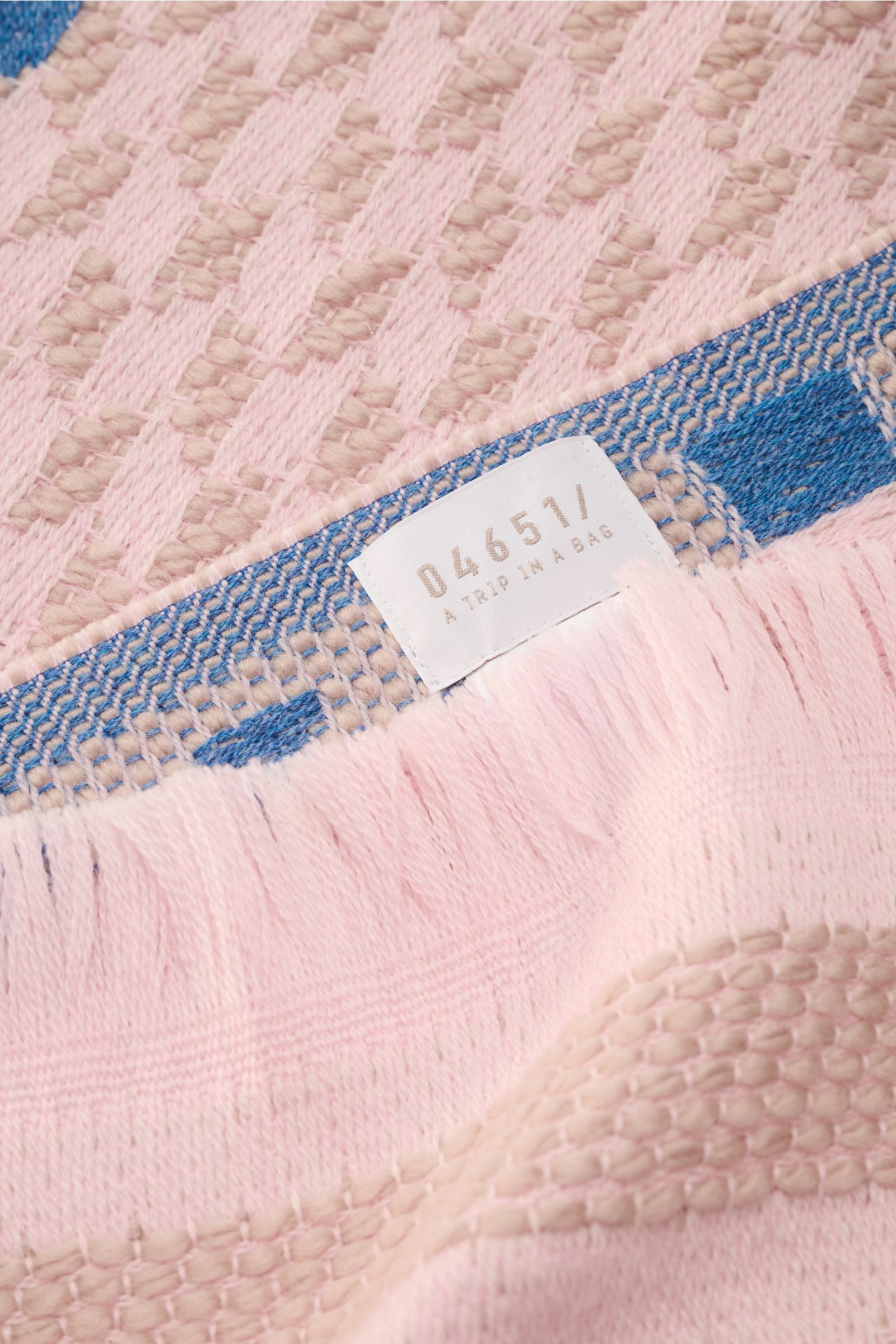 Close-up from above of the 04651/ A trip in a bag Scarf '3D Jacquard' rose/beige/smoky blue patterned showing fine pure virgin wool, soft feel, graphic pattern, narrow fringed edge.

Description: A luxurious eye-catcher for winter: Fine material in pur