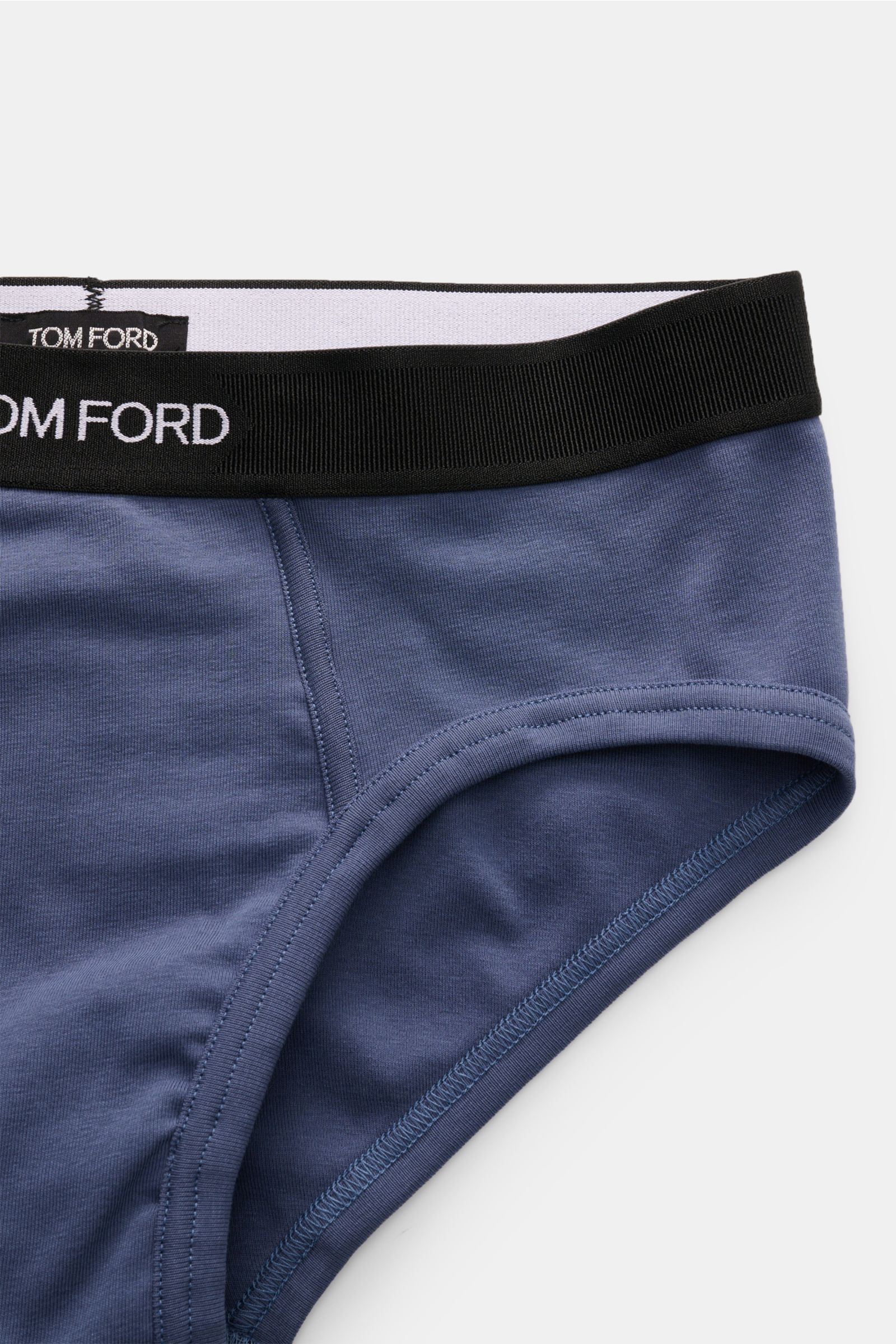 Close-up front-side view of Tom Ford Sport Slip graublau featuring a black elastic waistband with TOM FORD stitching, soft elastic cotton, slim fit, and side fly.

Für den richtigen Wohlfühlfaktor wählen wir die schlichten Boxershorts aus geschmeidigem