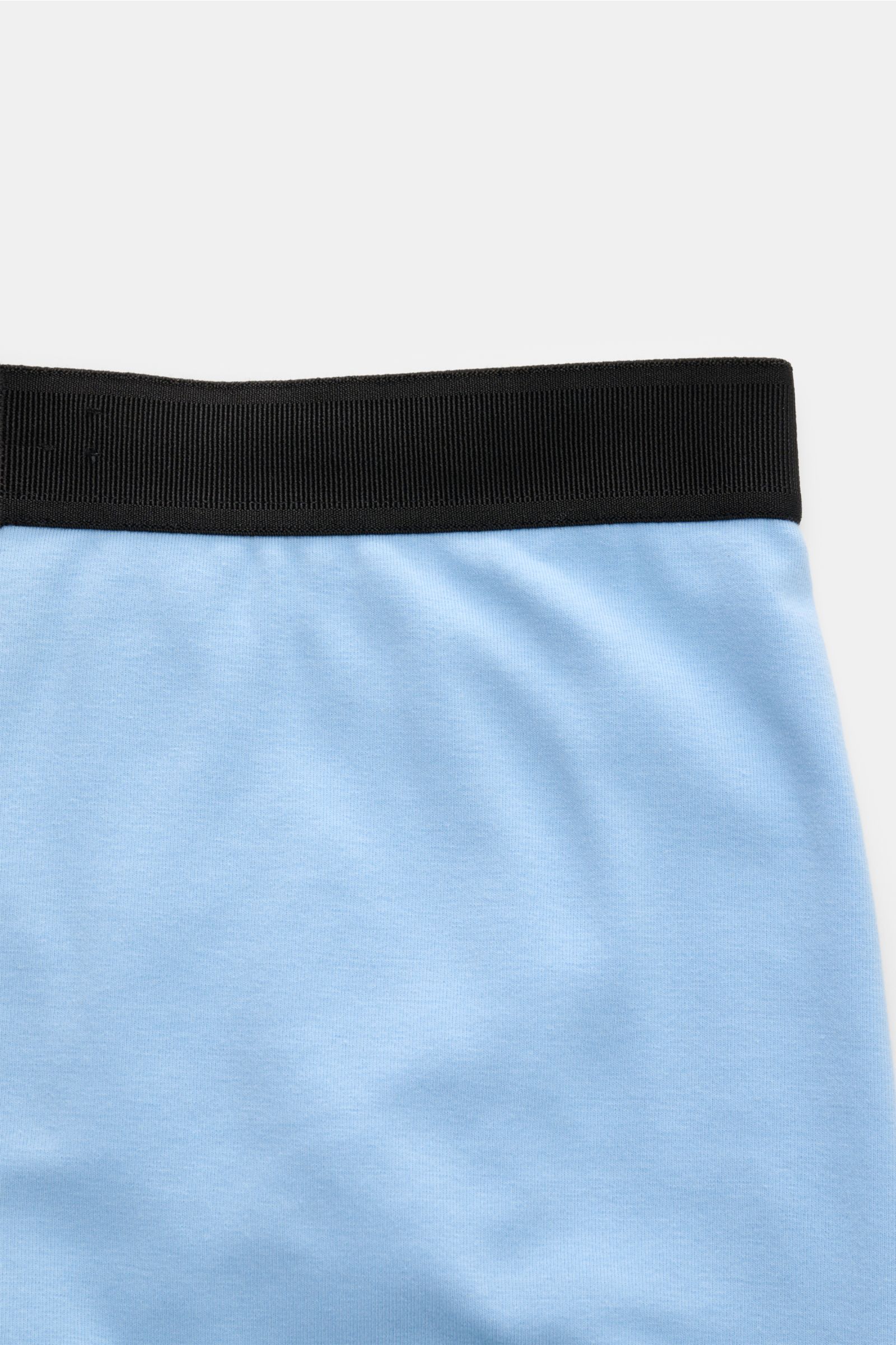 Tom Ford Boxershorts hellblau aus elastischer Baumwolle mit schwarzem Bund, seitlichem Eingriff und TOM FORD-Stitching, Slim Fit, Frontansicht.