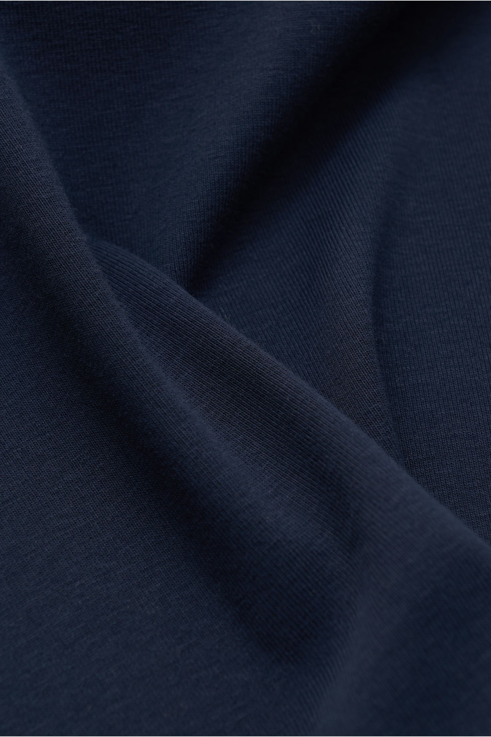 Nahaufnahme des weichen, leichten Jersey-Stoffs des Tom Ford Rundhals-Unterhemds navy, gefertigt aus Baumwolle mit Stretch-Anteil, Extra Slim Fit, Rundhalsausschnitt und kleinem Label-Patch am Saum.