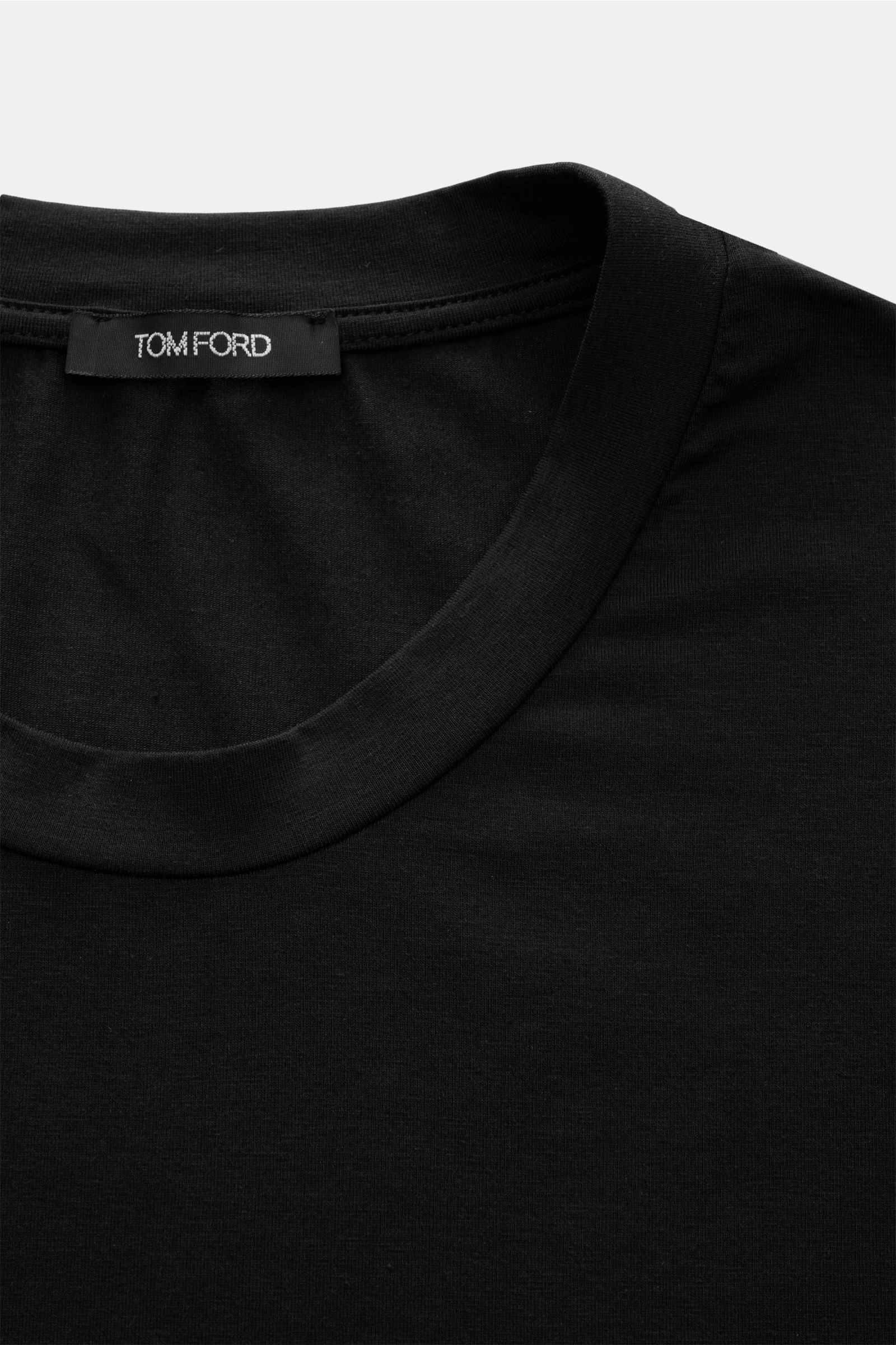 Close-up front view of the Tom Ford Rundhals-Unterhemd schwarz showing the round neckline and TOM FORD label, made of cotton-modal blend with a soft touch, regular fit, and small TOM FORD woven label at the hem.