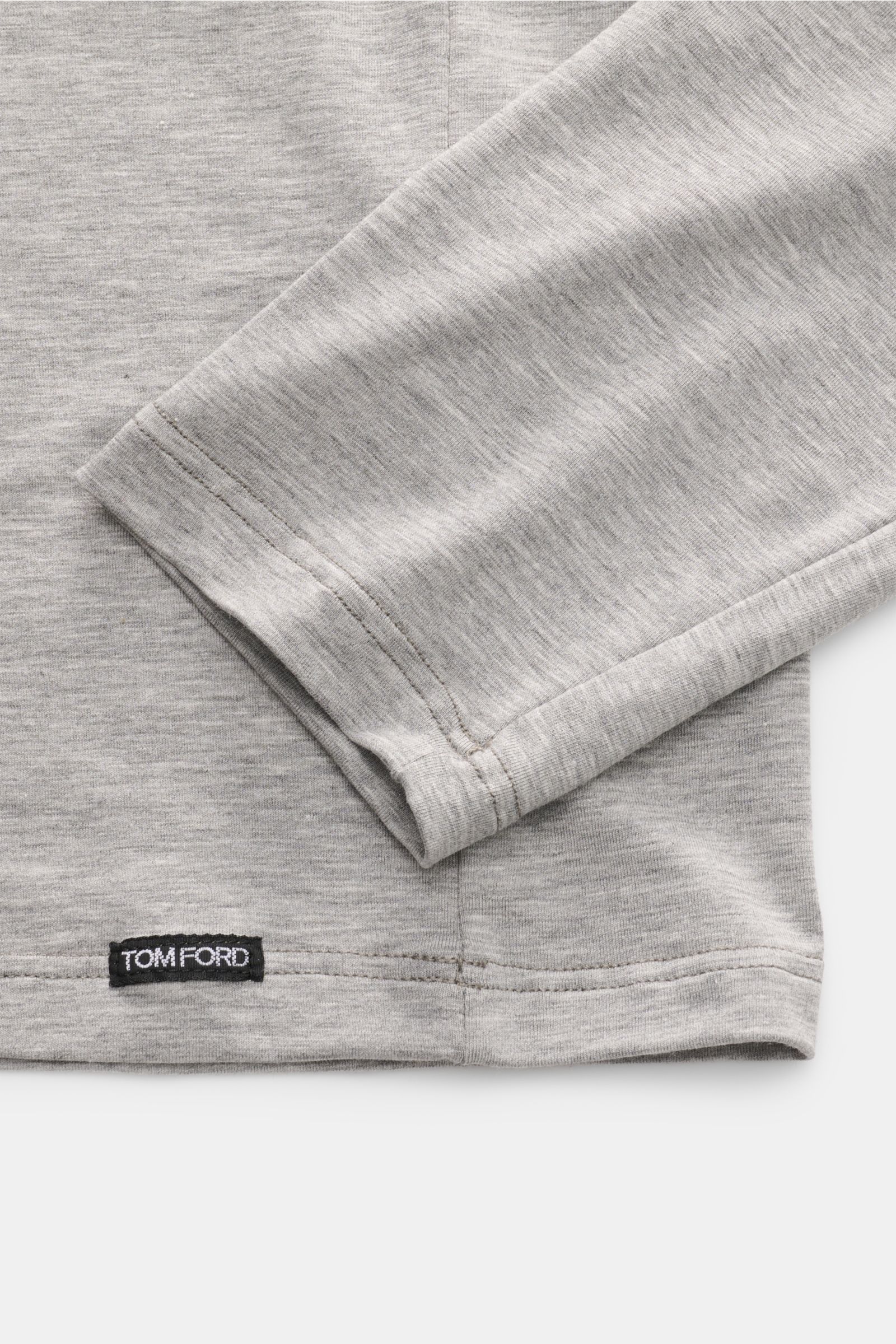 Close-up of the sleeve and hem of the Tom Ford Langarm-Unterhemd schwarz, showing soft cotton-modal fabric and small TOM FORD label, photographed from above.

Description: Cleanes Basic mit Rundhalsausschnitt: Das komfortable Langarmshirt aus hochwerti