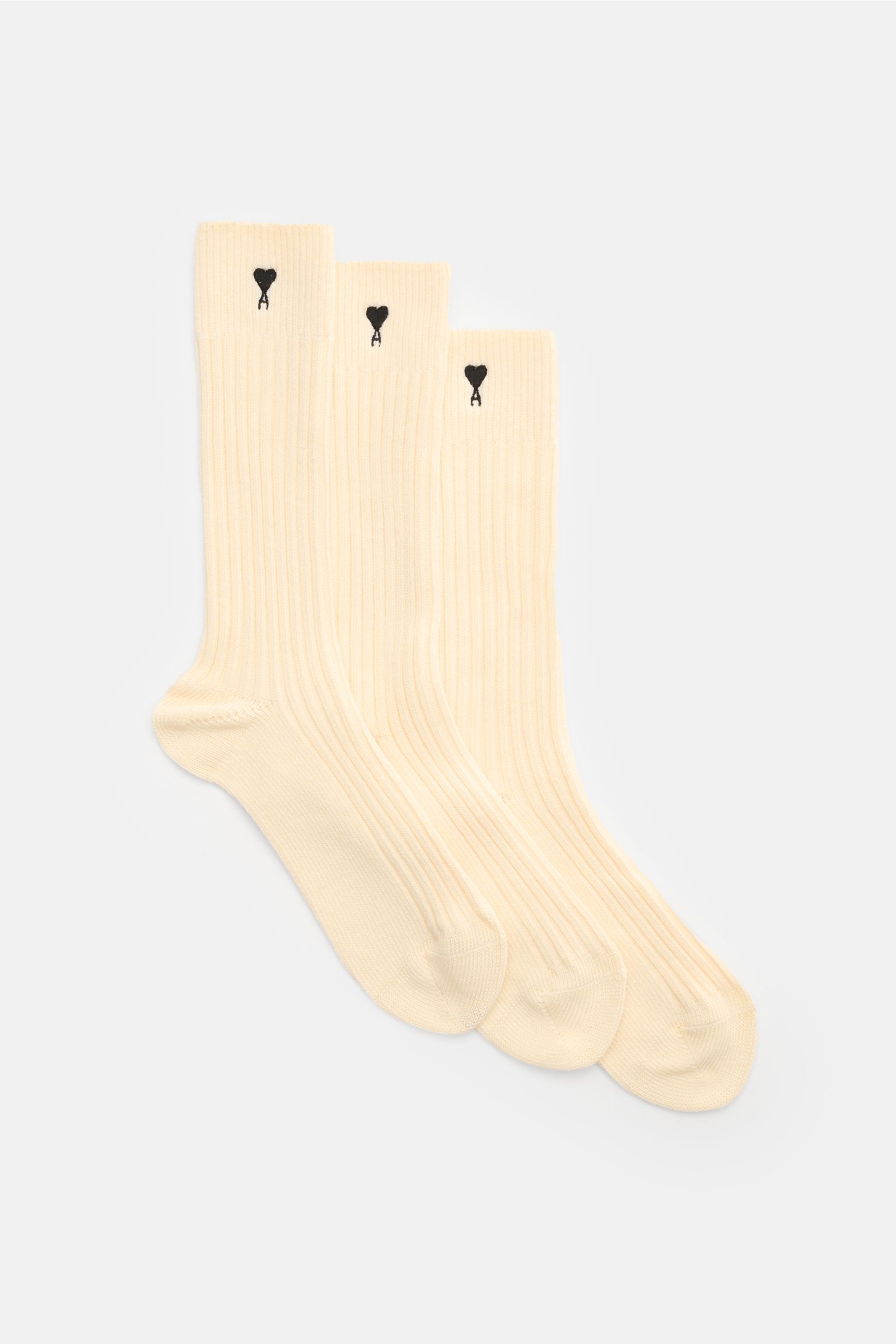 Front view of Ami Paris Socks pack of 3 pairs cream with rib knit, reinforced heel and toe, wide bands, and signature heart stitching.

Description: French label AMI PARIS has added its signature stitching to transform this pack of 3 pairs of socks fro