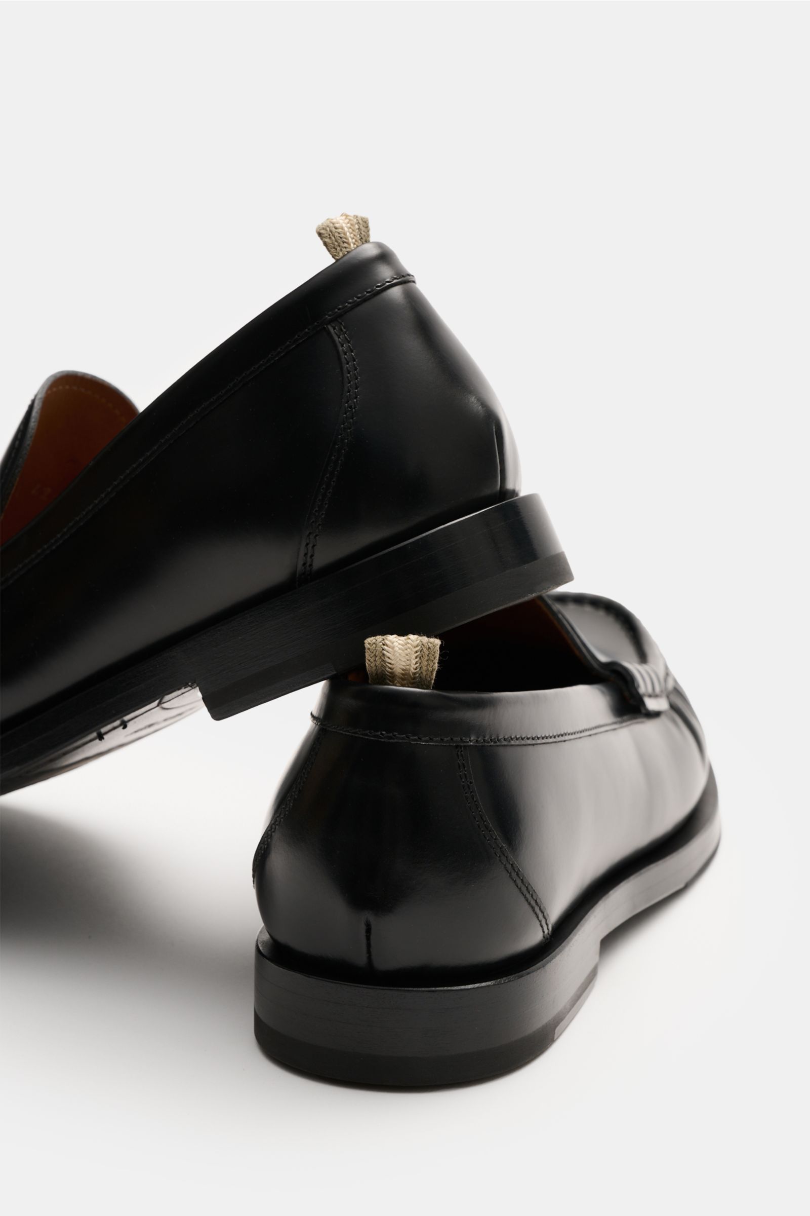 Officine Creative Penny Loafer 'Balfron' schwarz aus poliertem Glattleder, leicht schmal zulaufend, mit Penny Strap, Zierfalten, ledernem Innenfutter, Gummisohle, Rückansicht seitlich fotografiert.