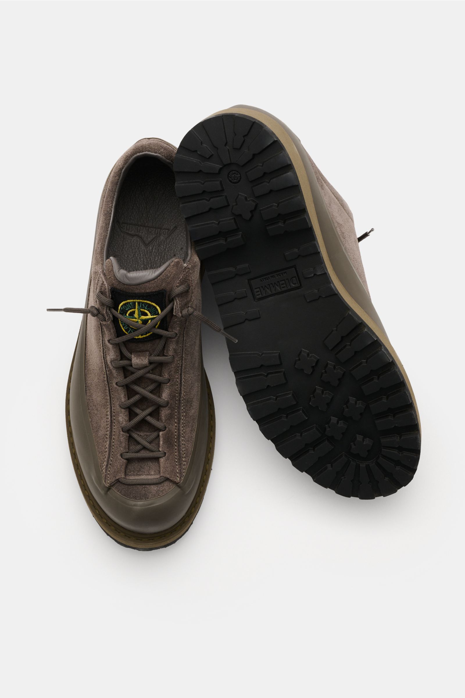 Stone Island Sneaker oliv aus Veloursleder mit profilierter Gummisohle, Acht-Loch-Schnürung und Logo-Patch, von oben und unten fotografiert.