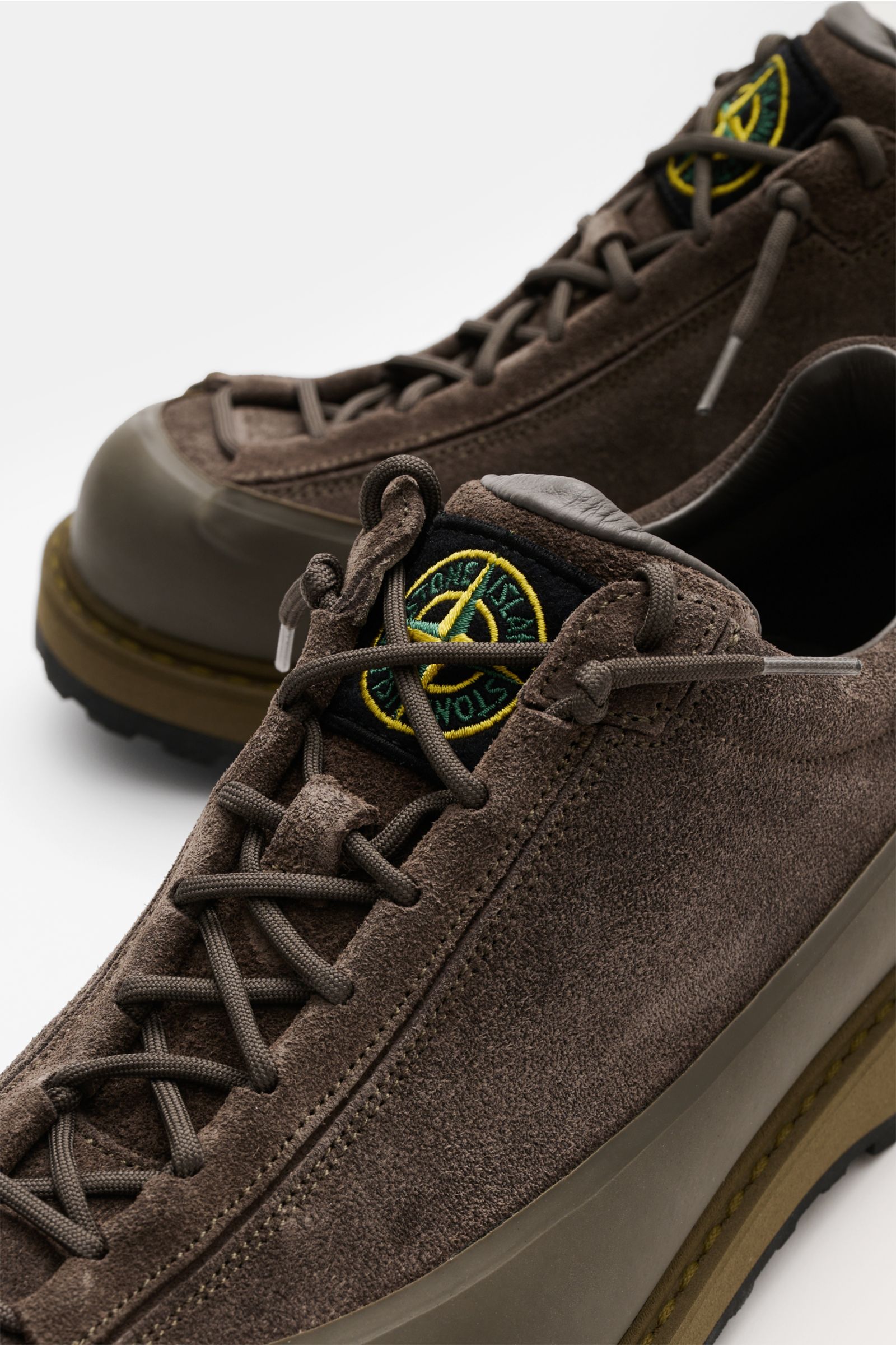 Stone Island Sneaker oliv aus Veloursleder mit profilierter Gummisohle, Acht-Loch-Schnürung, Logo-Patch und gepolstertem Schaftrand, Nahaufnahme von schräg oben.