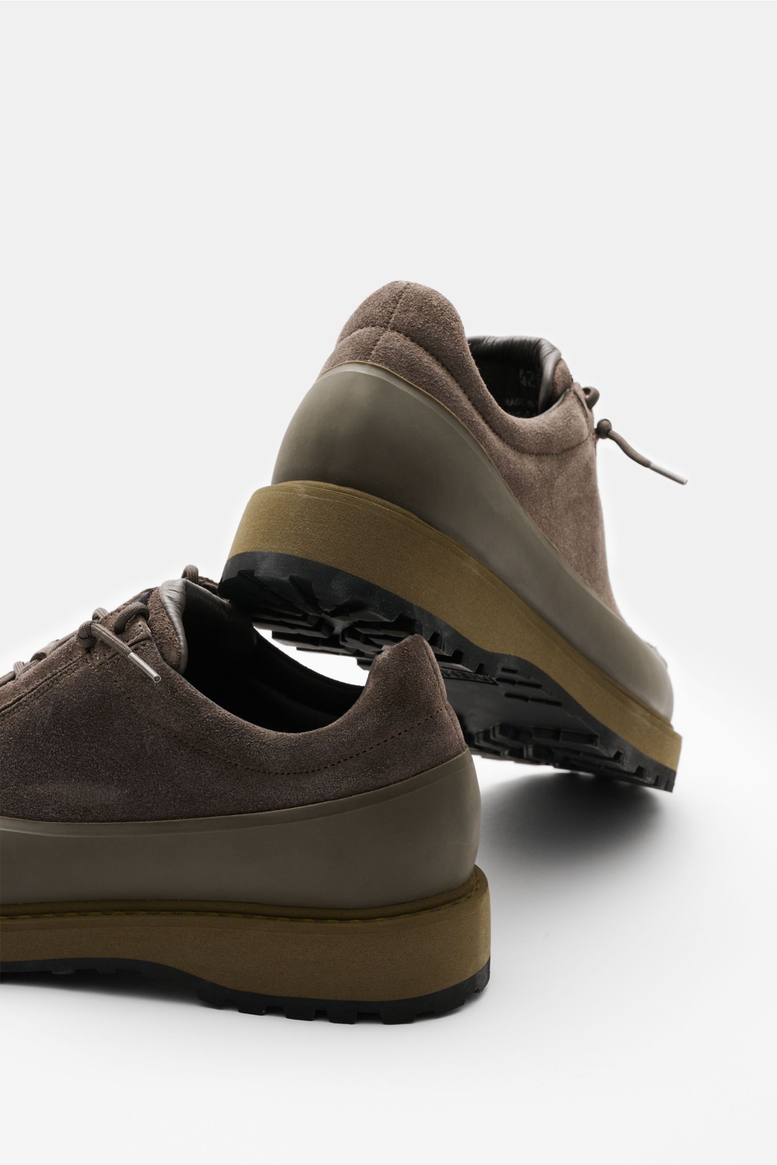 Stone Island Sneaker oliv aus Veloursleder mit profilierter Gummisohle, Acht-Loch-Schnürung, runder Vorderkappe, von hinten schräg fotografiert.