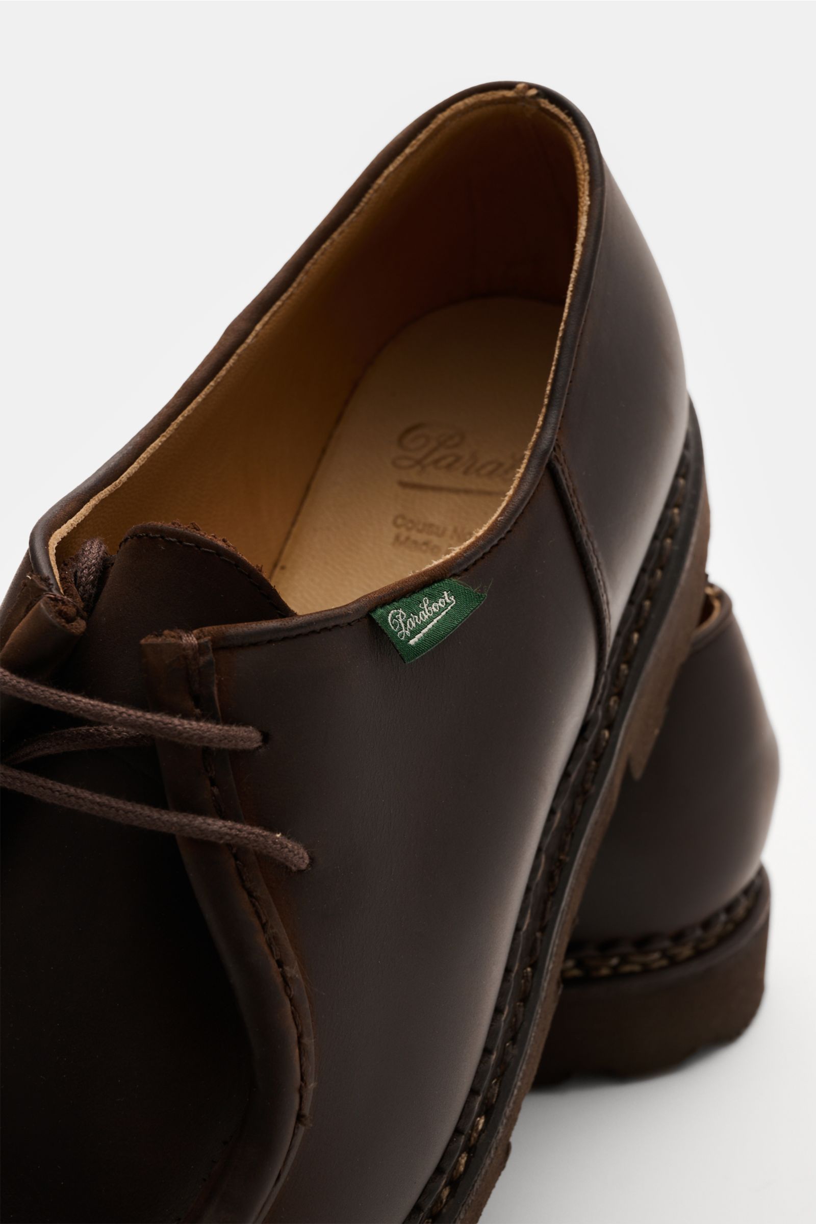 Paraboot Schnürer 'Michael' dunkelbraun shown from a close-up top-side angle, featuring smooth dark brown leather, two-hole lacing, discreet green PARABOOT label, leather lining, and robust rubber sole. A timeless classic designed by Michel Richard in 194