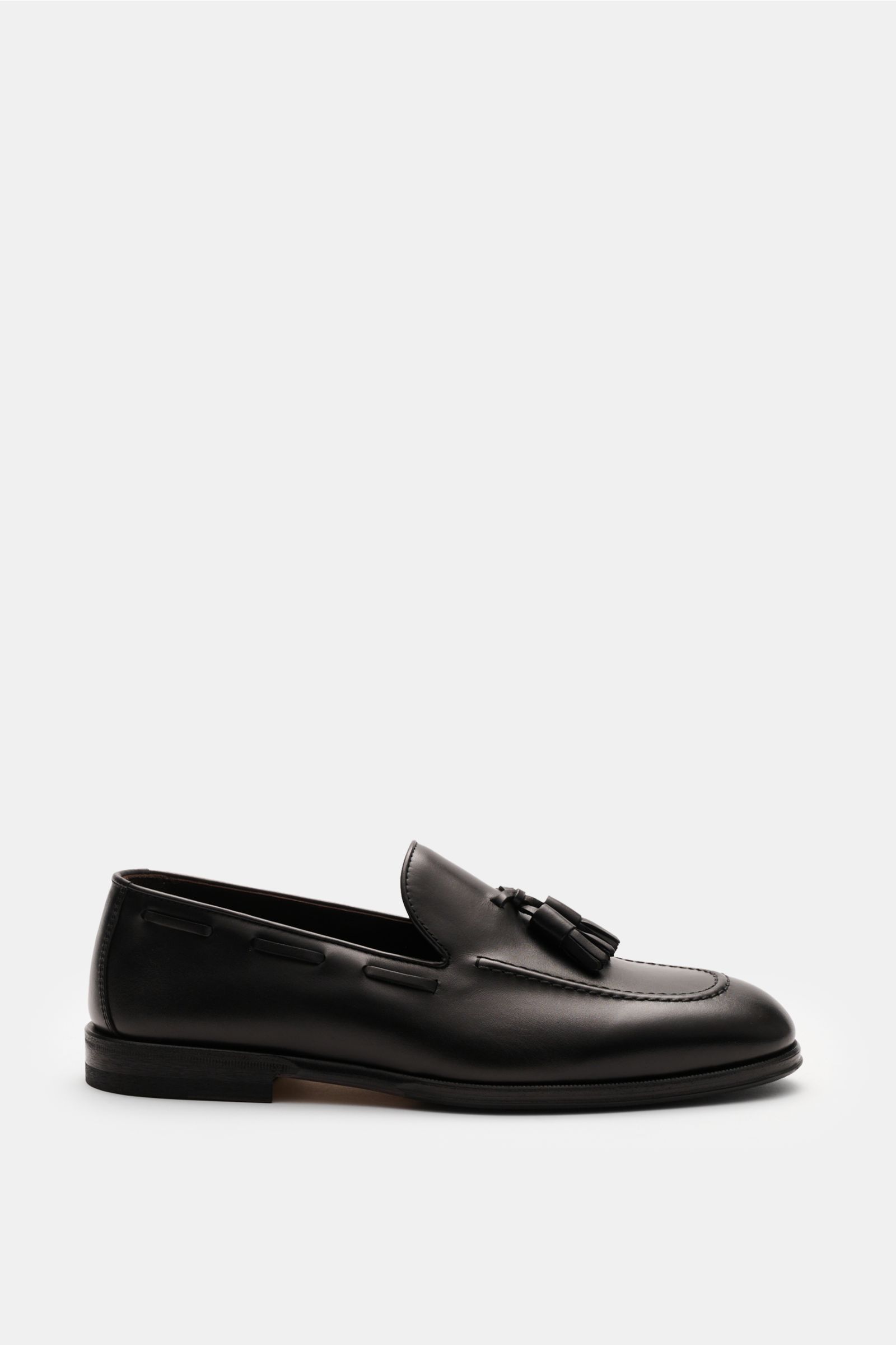Henderson Tassel Loafer dunkelbraun shown from the side, crafted from hand-antiqued calf leather with a slim silhouette, tassel detail, Blake construction, leather lining, leather and rubber sole, and rubber-reinforced heel. 

Ein Statement klassischer